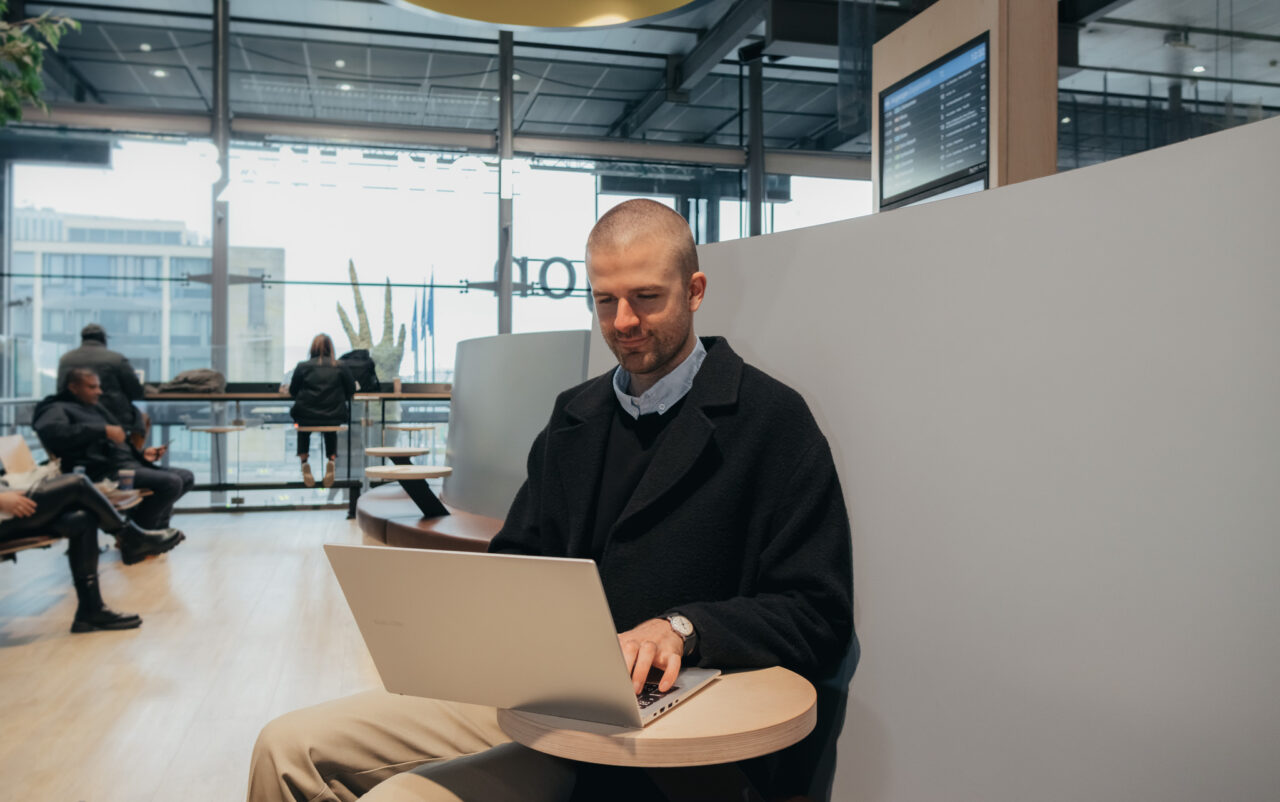 En man sitter å jobber på pc sin. Foto.