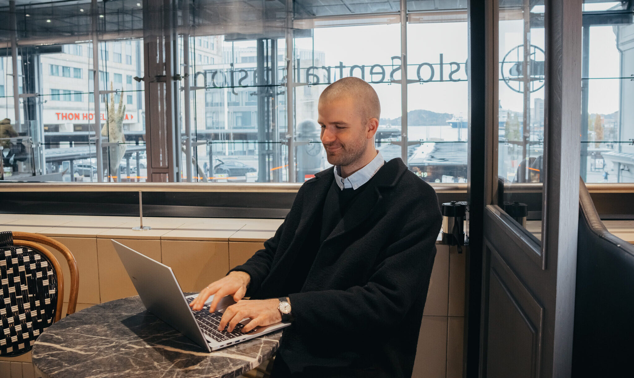 En man sitter å jobber på pc sin. Foto.