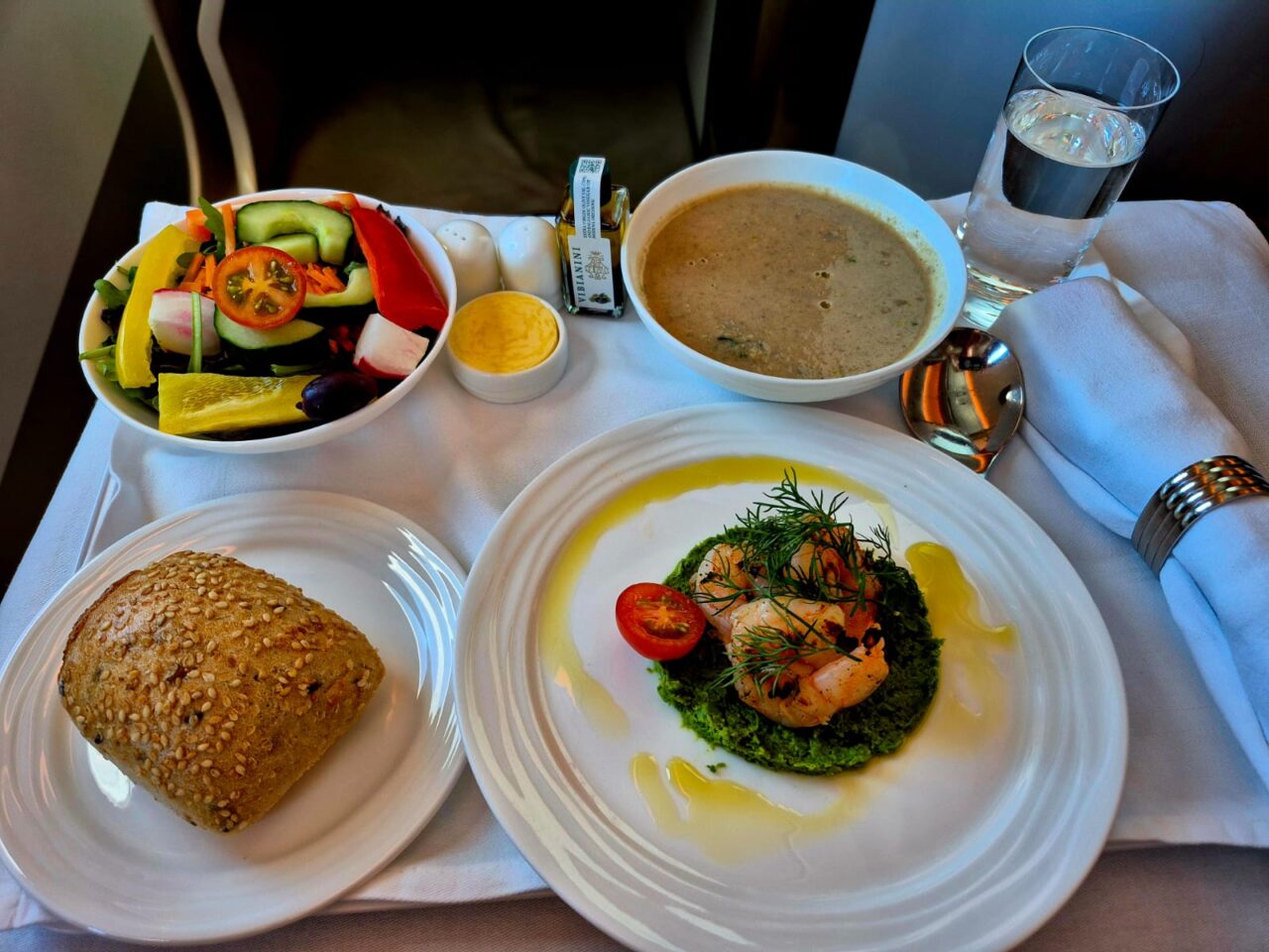 Tallerkner med salat, suppe, brød og scampi. Foto