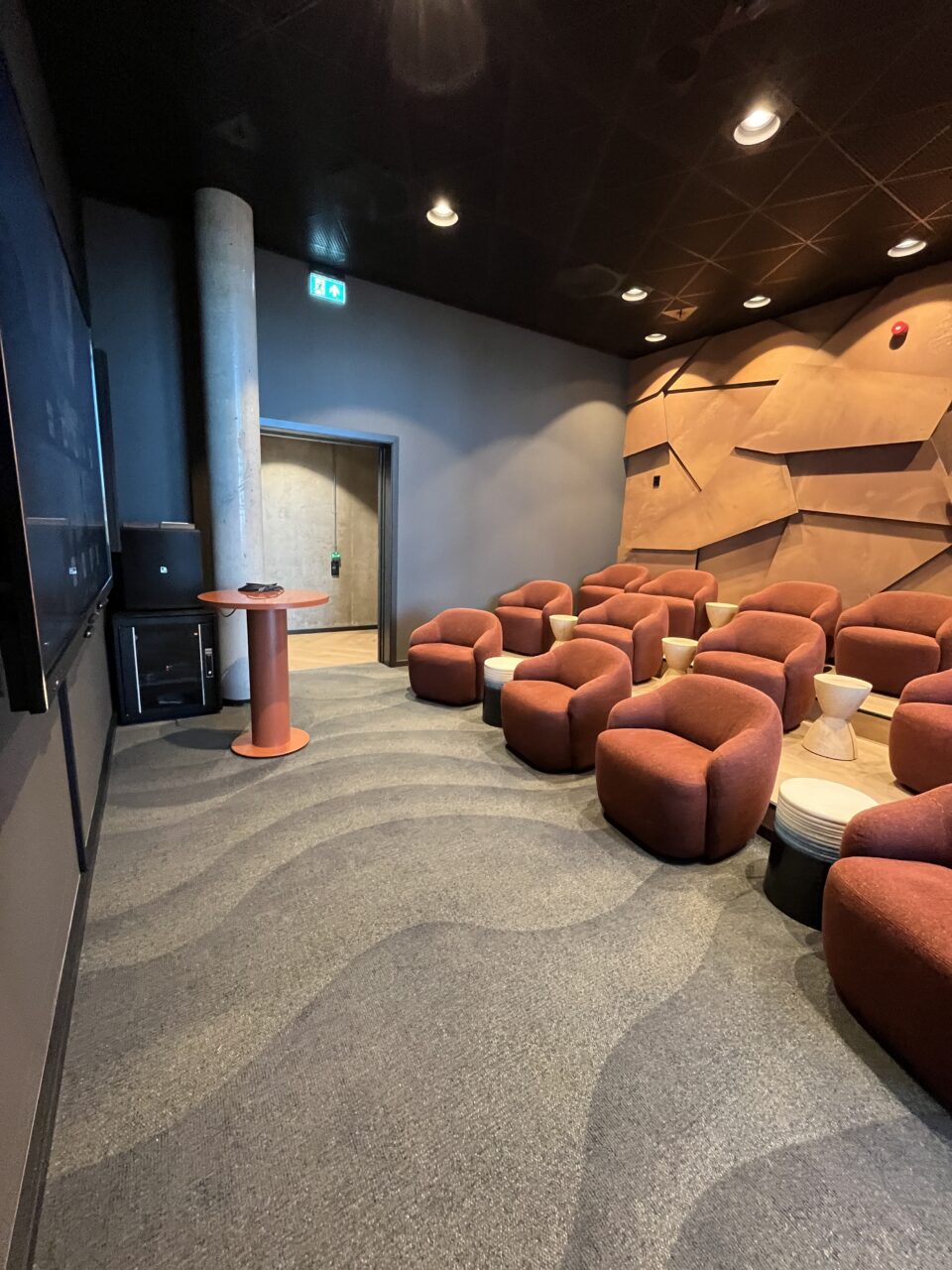 Møterom med behagelige stoler vendt mot en skjerm. Foto