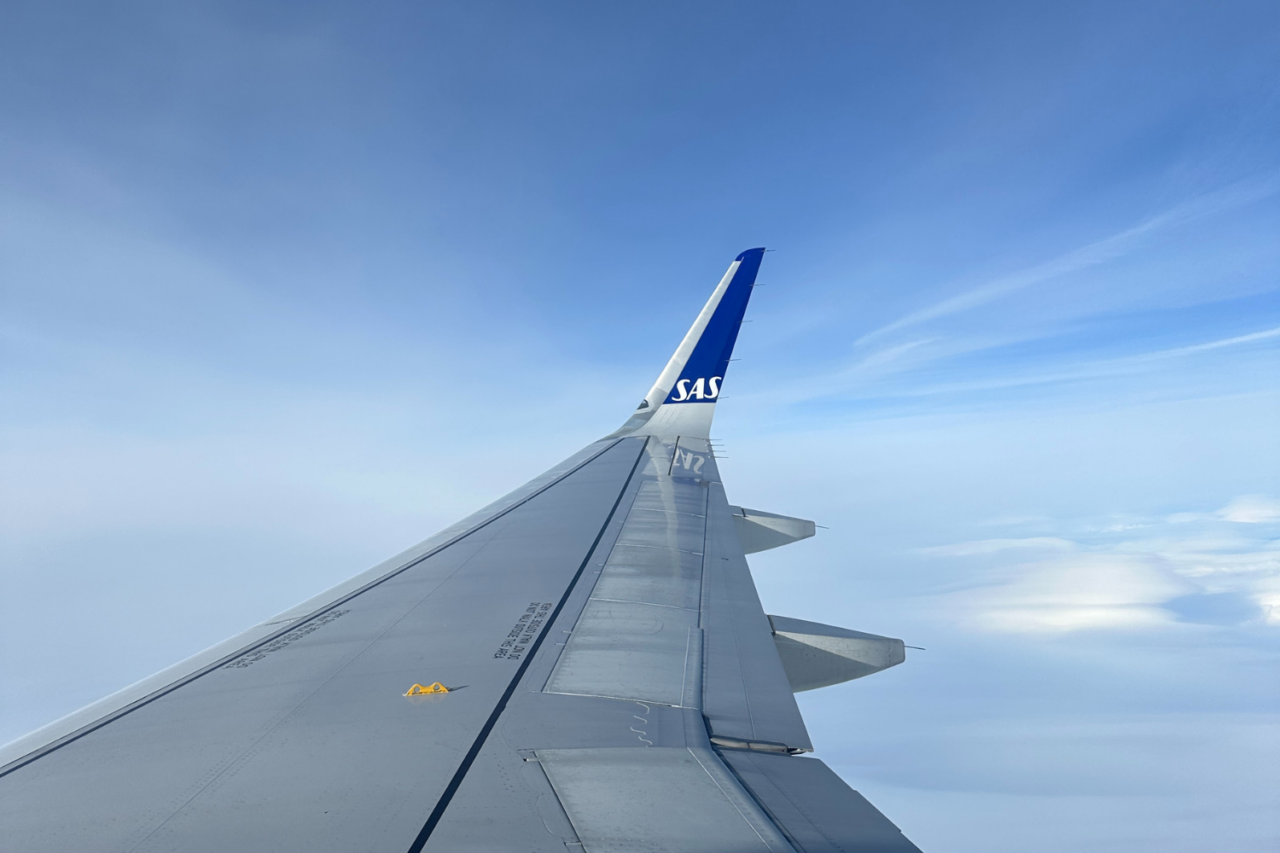 Utsikt over en SAS-flyvinge ut av et flyvindu. Foto