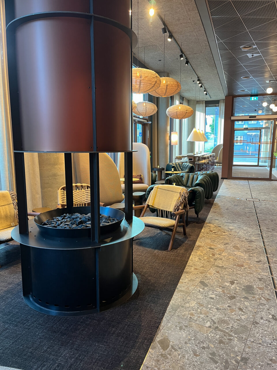 En lobby på et hotell med peis og sitteplasser. Foto
