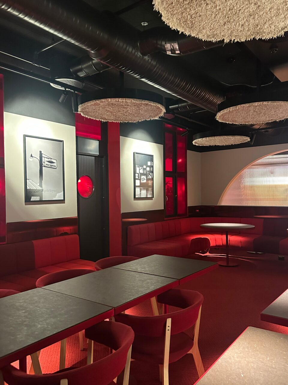 Et rødt lokale med sofa og lamper. Foto