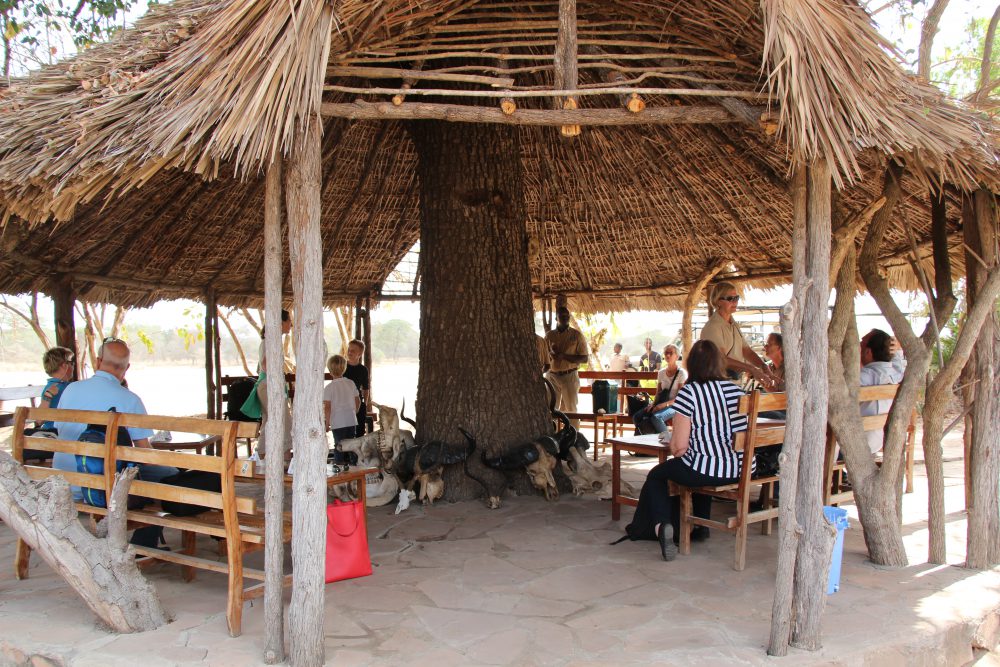 Familie sitter inne i stråhytte i Zanzibar