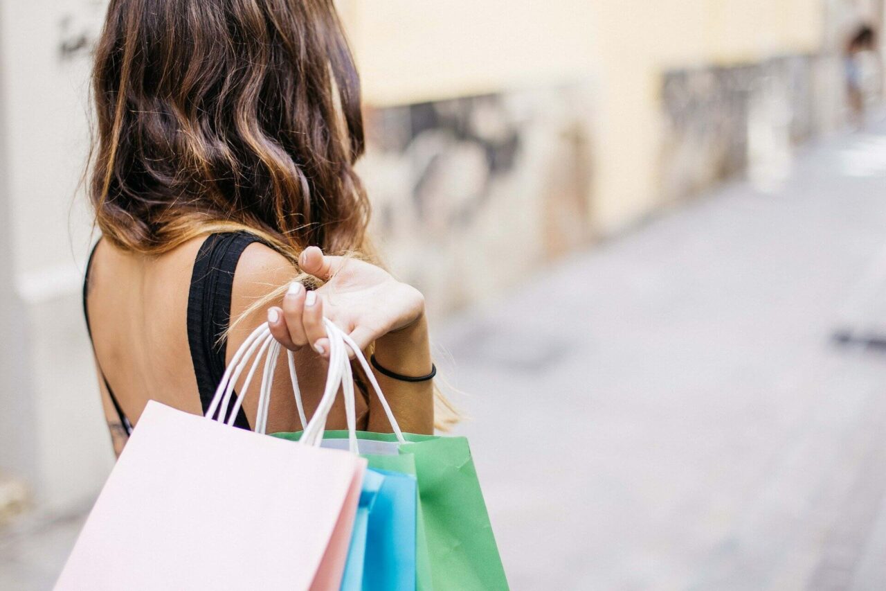 Jente på shopping som holder handleposer i hånden