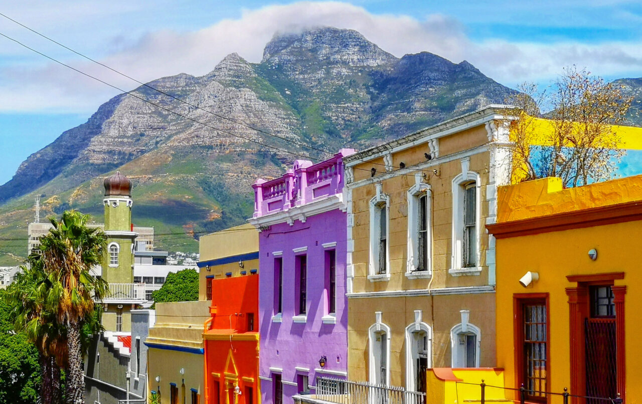 Fargerike hus på rekke og rad i Bo-Kaap med Table Mountain i bakgrunnen. Foto