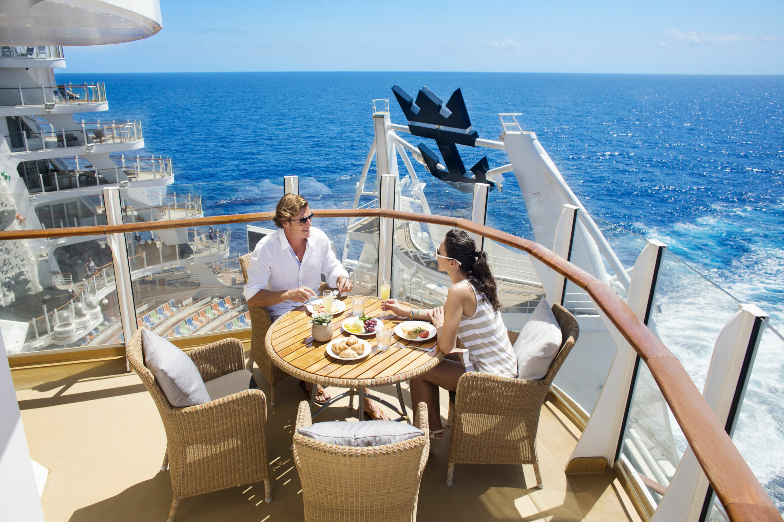 En mann og en kvinne som spiser frokost utre på terrassen om bord cruiseskipet Symphony of the Seas