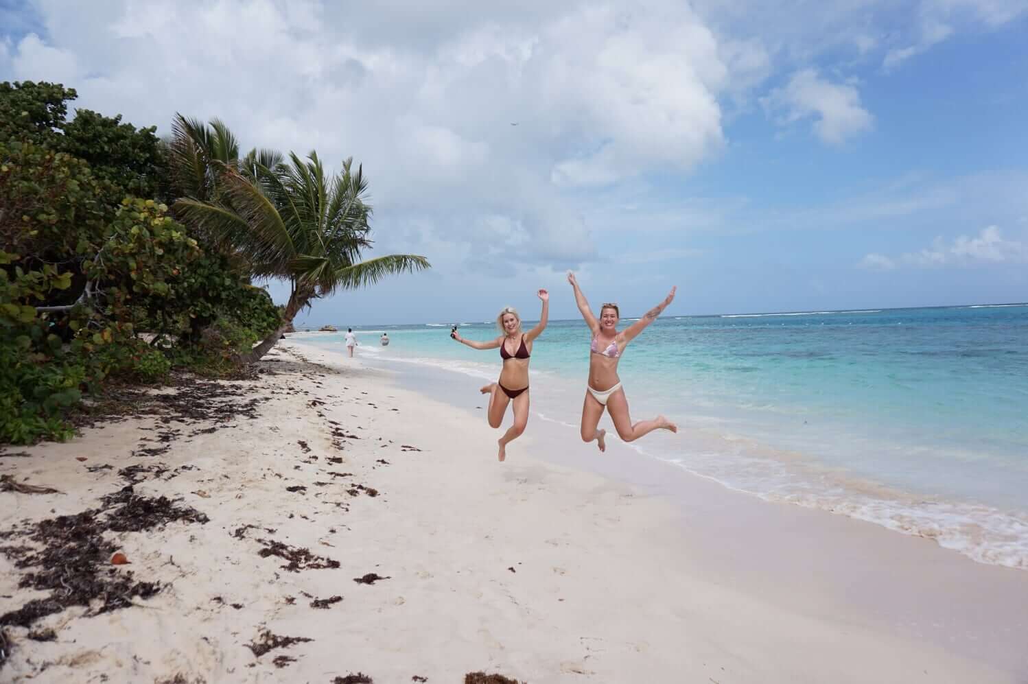 Hoppende glade jenter på Flamenco Beach, Culebra, Puerto Rico