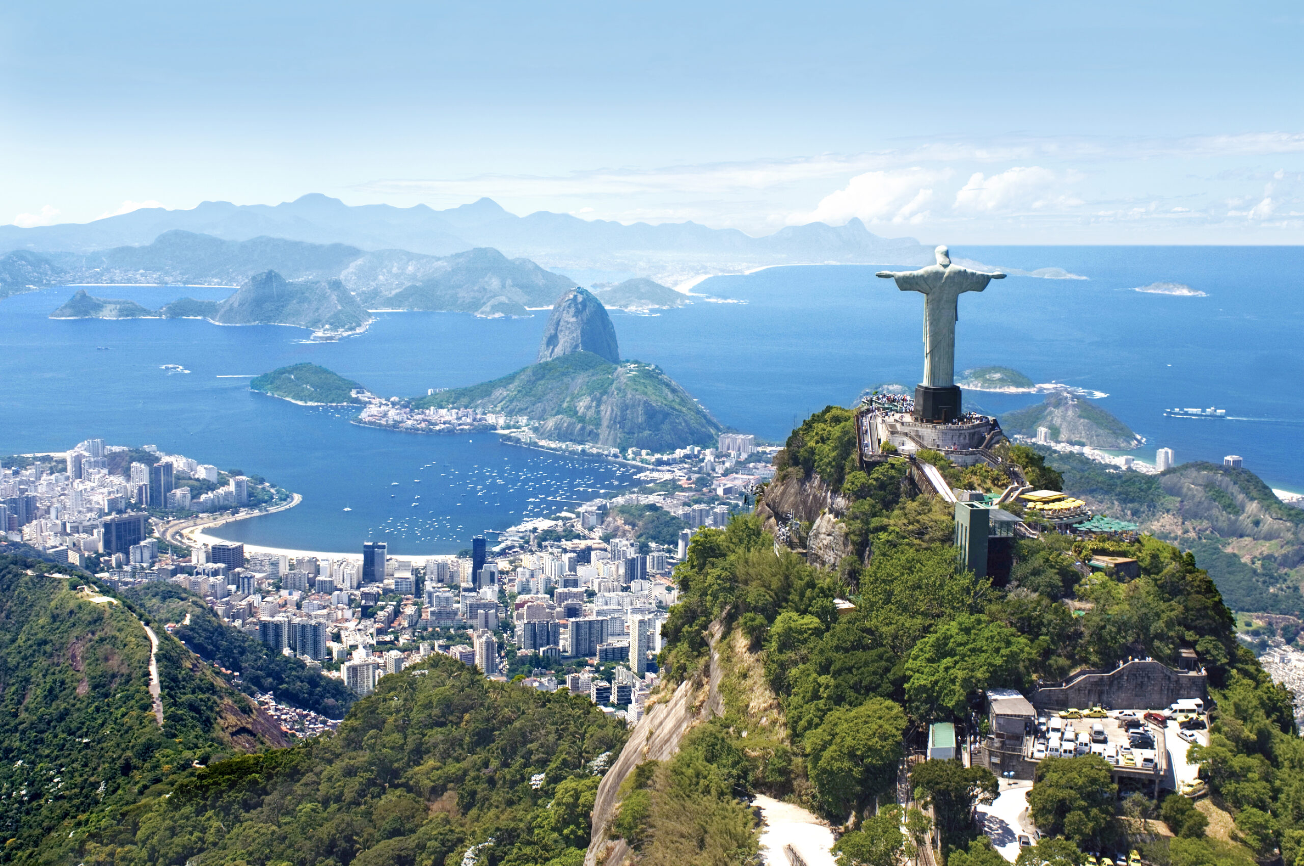 En stor statue av Kristus står på en høyde og speider ut over havet og byen Rio de Janeiro i Brasil