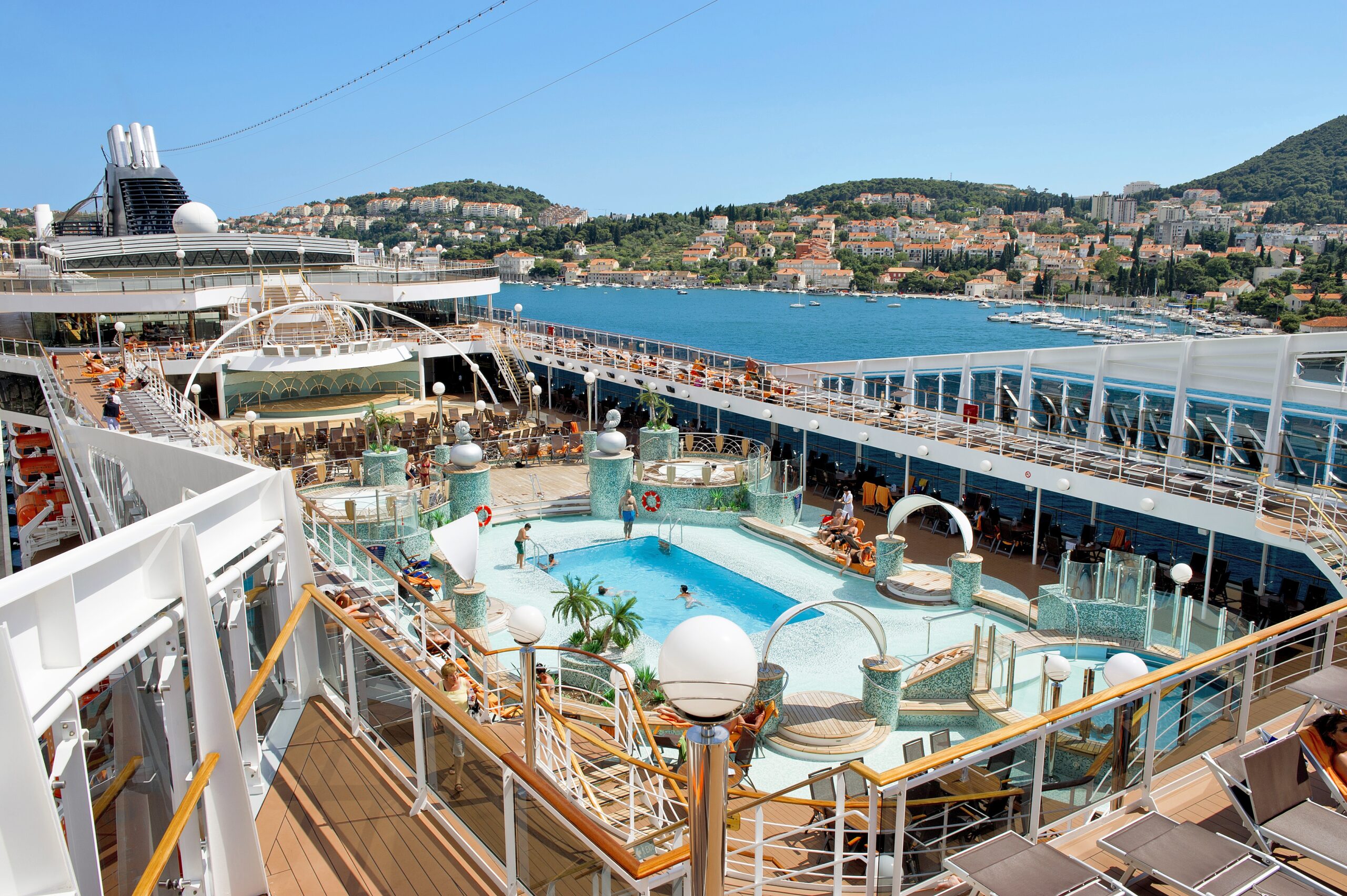 Stort bassengområde med solsenger og mennesker som koser seg i solen, om bord cruiseskipet MSC Magnifica Le Grand Bleu