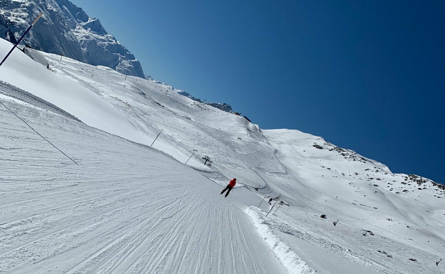 Lang skibakke og person som står på ski