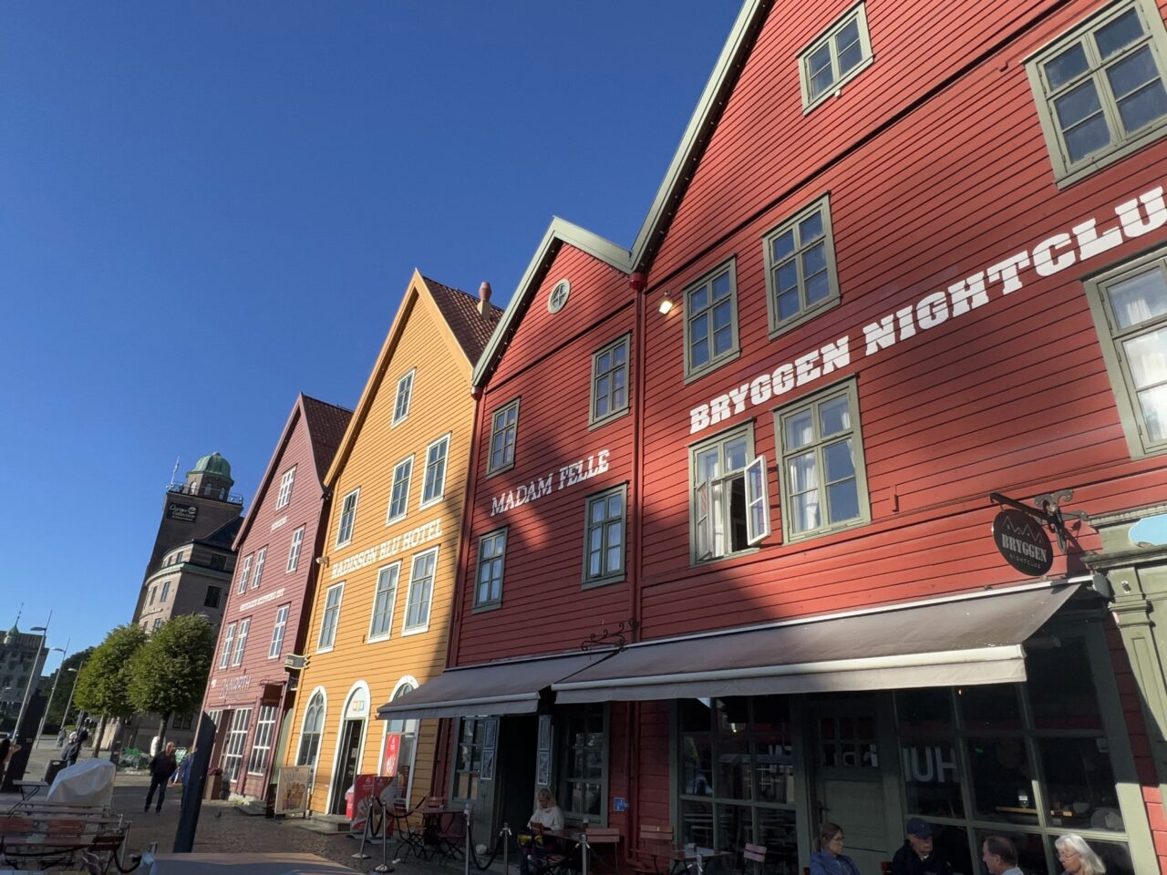 Fargerike gamle trehus på rekke og rad langs bryggen