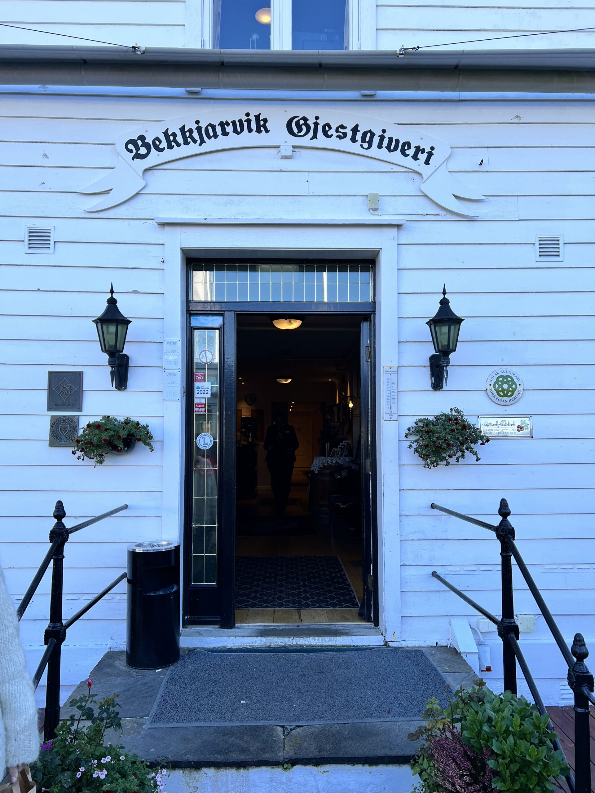 Inngangsparti med steintrapp og skilt til Gjestgiveriet