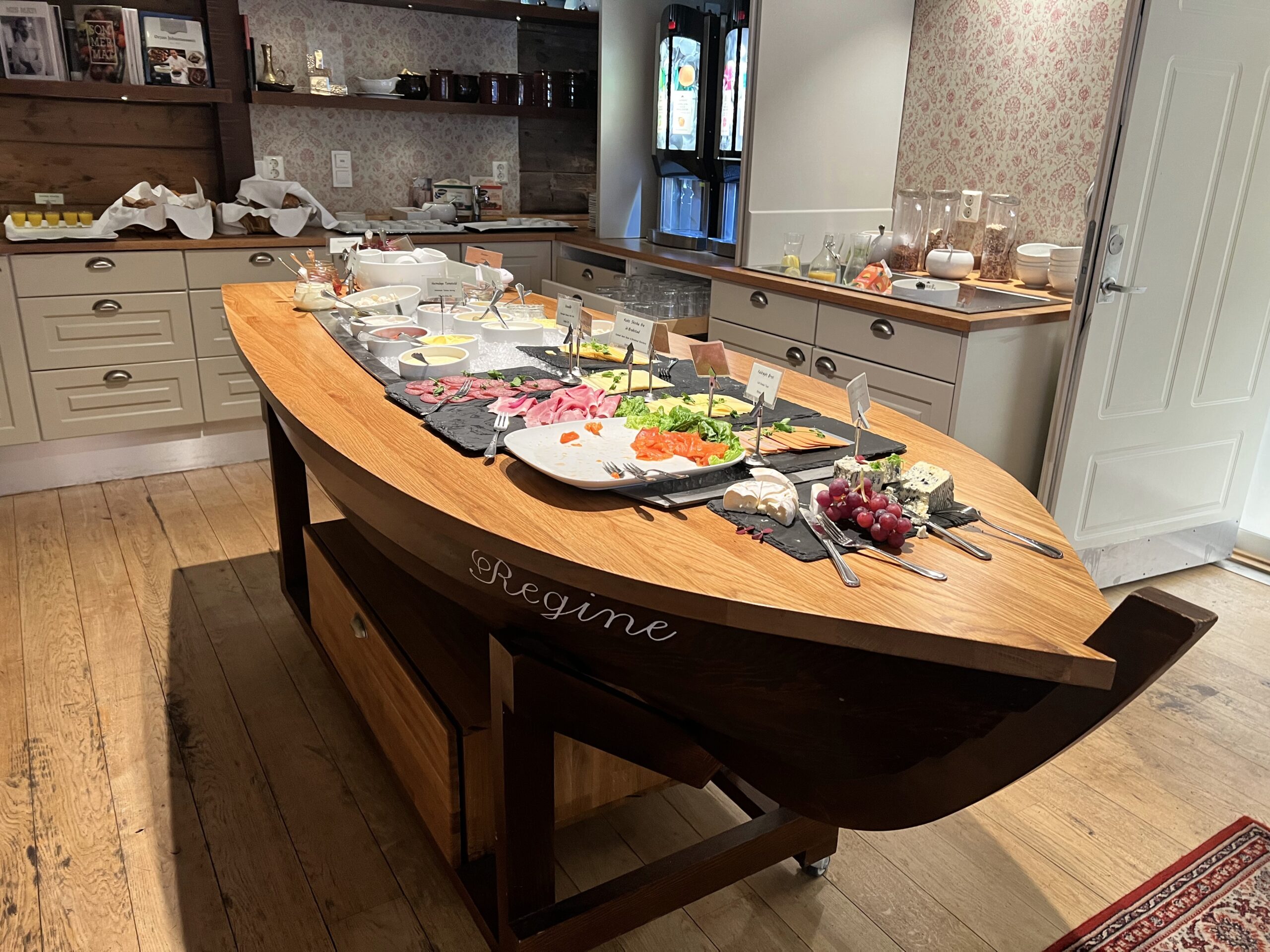 Frokostbuffet bestående av ulike typer pålegg, servert på en stor trebåt