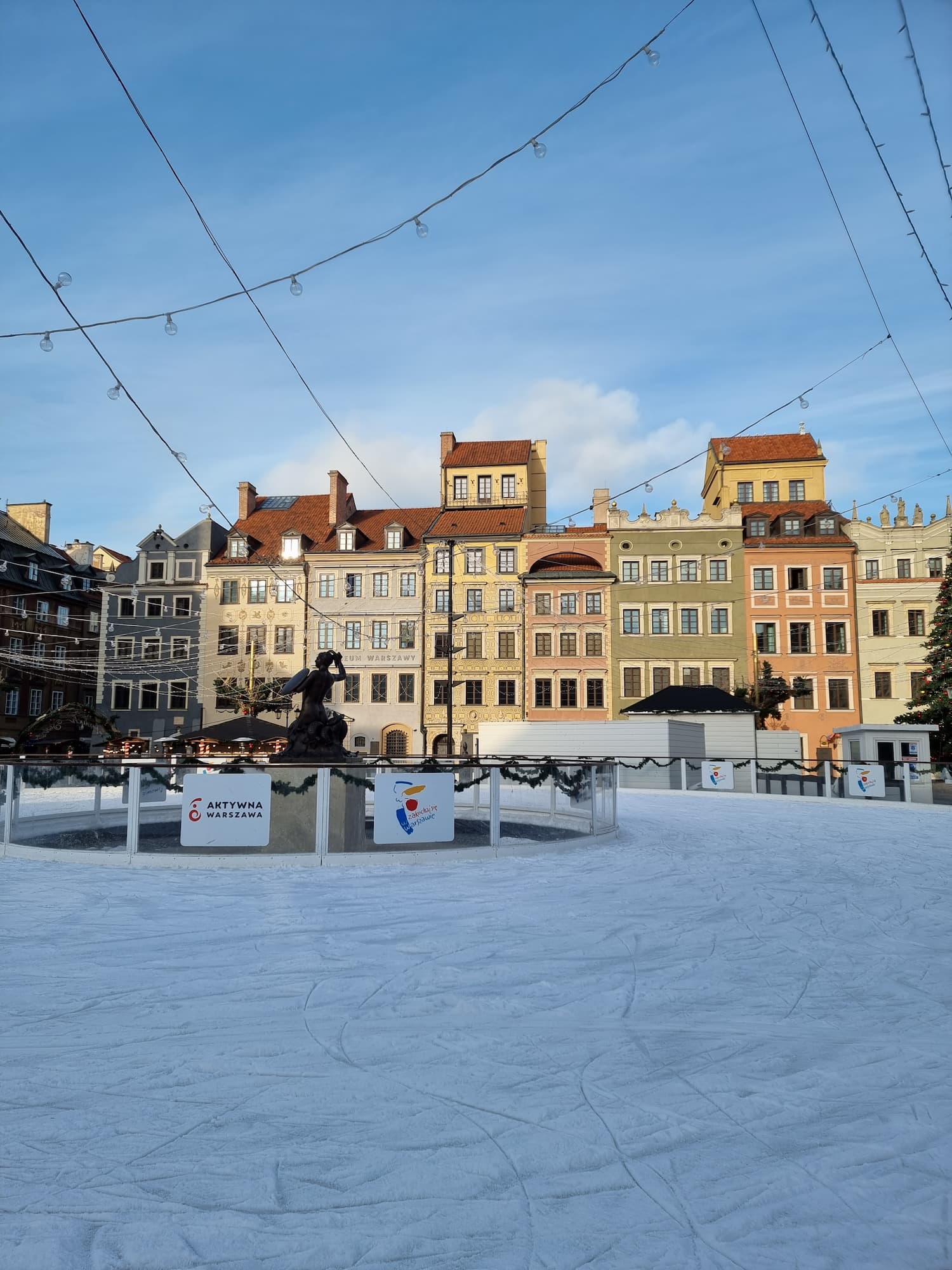 En skøytebane i forkant av vakre fargerike bygninger. Foto.