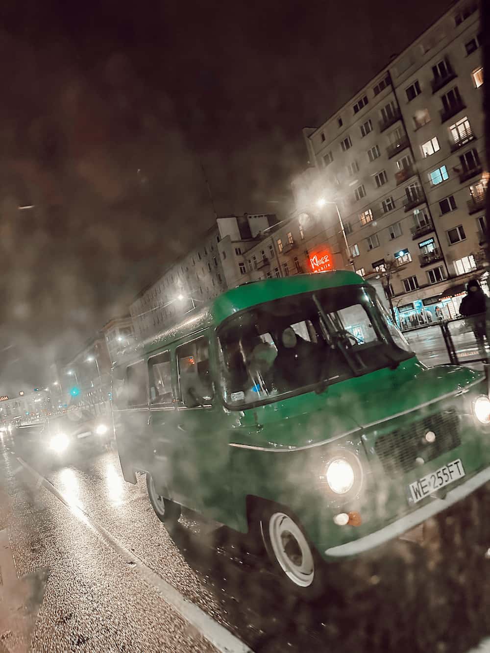 Grønn retro-van som kjører i mørket. Foto