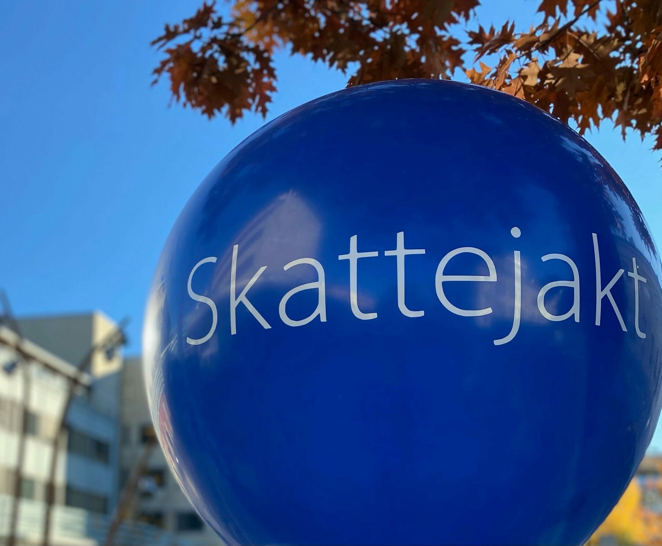 En stor blå ballong med hvit tekst hvor det står skattejakt. Foto