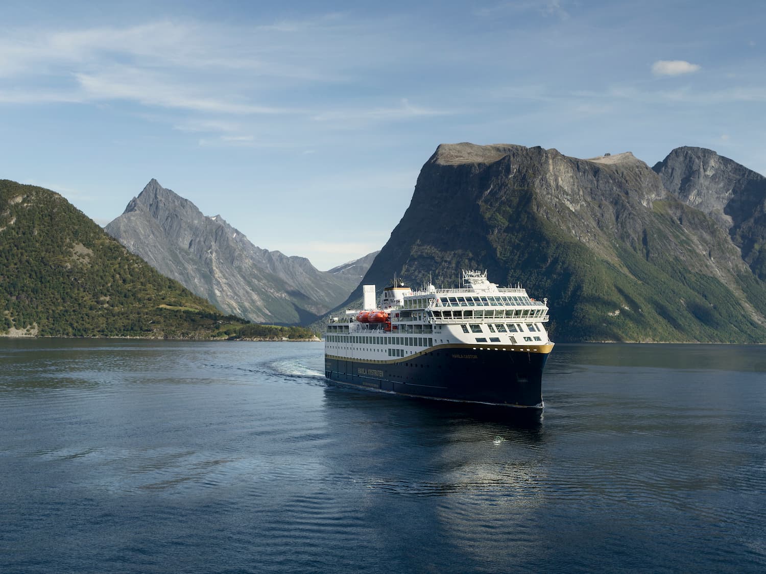 Cruiseskip midt blant fjord og høye fjell. Foto