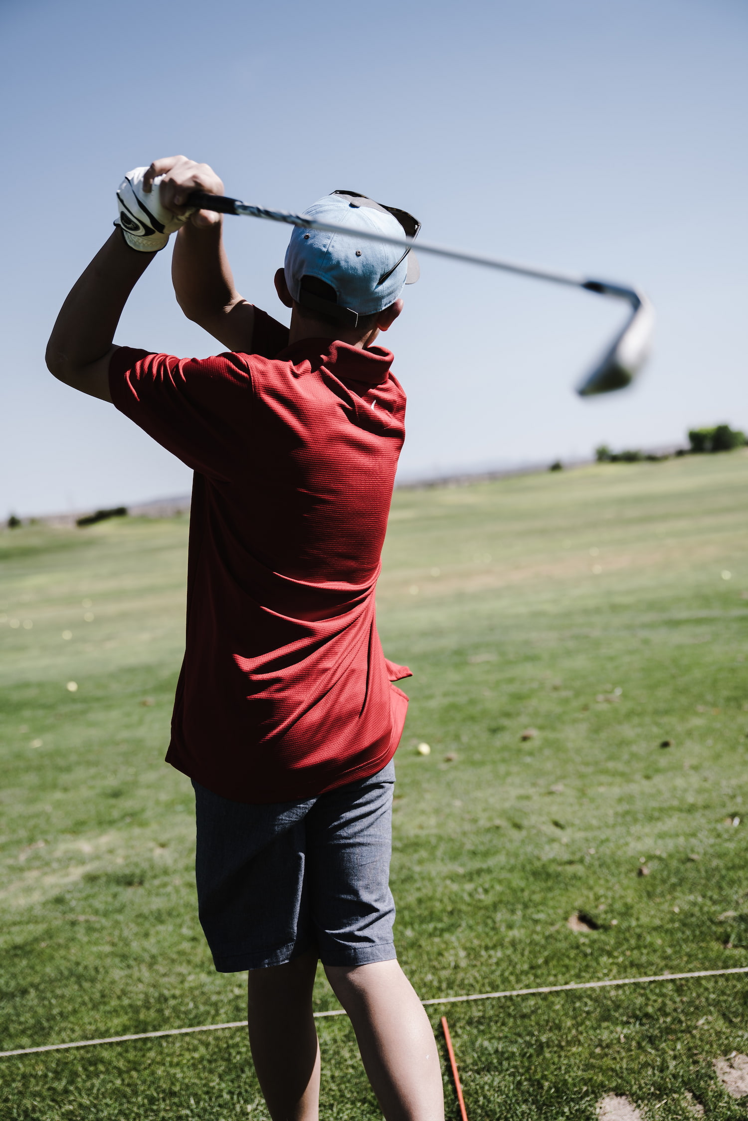 En mann som spiller golf i grønne omgivelser. Foto