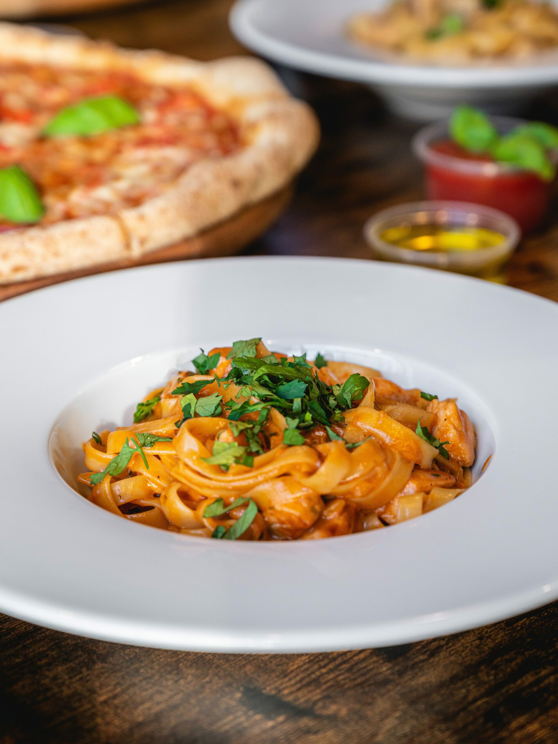 Fersk pasta servert på en hvit tallerken. Foto