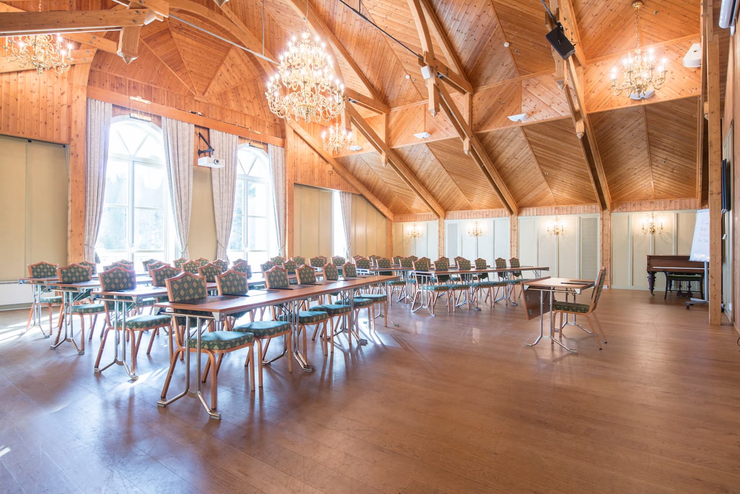 Stol lys konferansesal med god takhøyde og lysekrone. Foto