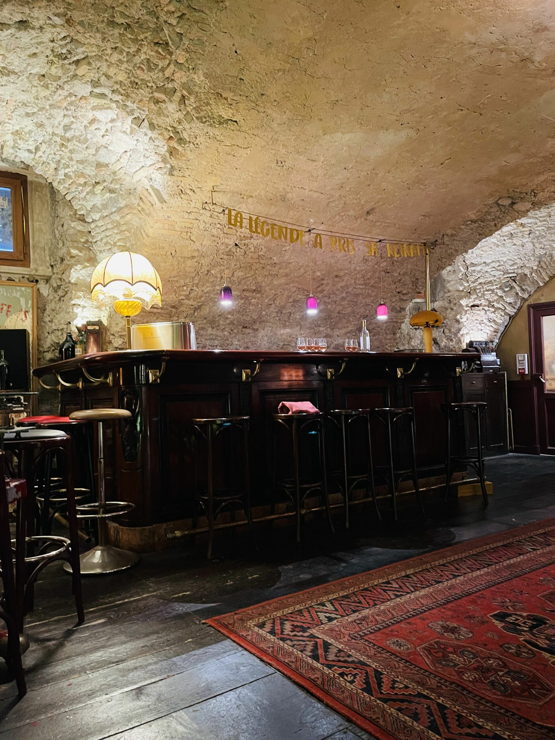 Selskapslokale og vinkjeller med mursteinstak, bar og barstoler. Foto