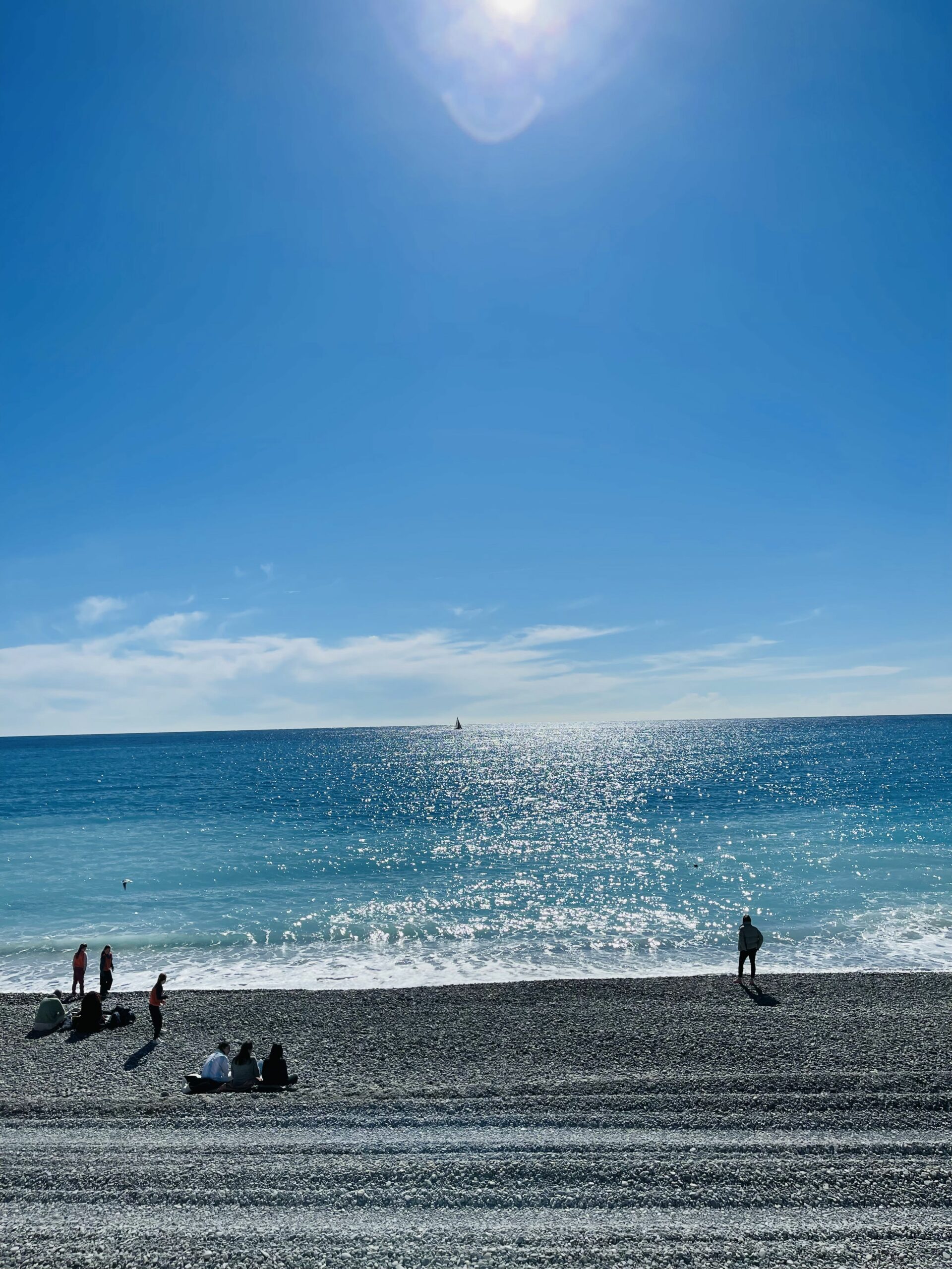 Stranden i Nice. Blått hav så langt øyet kan se nydelig vær. Foto