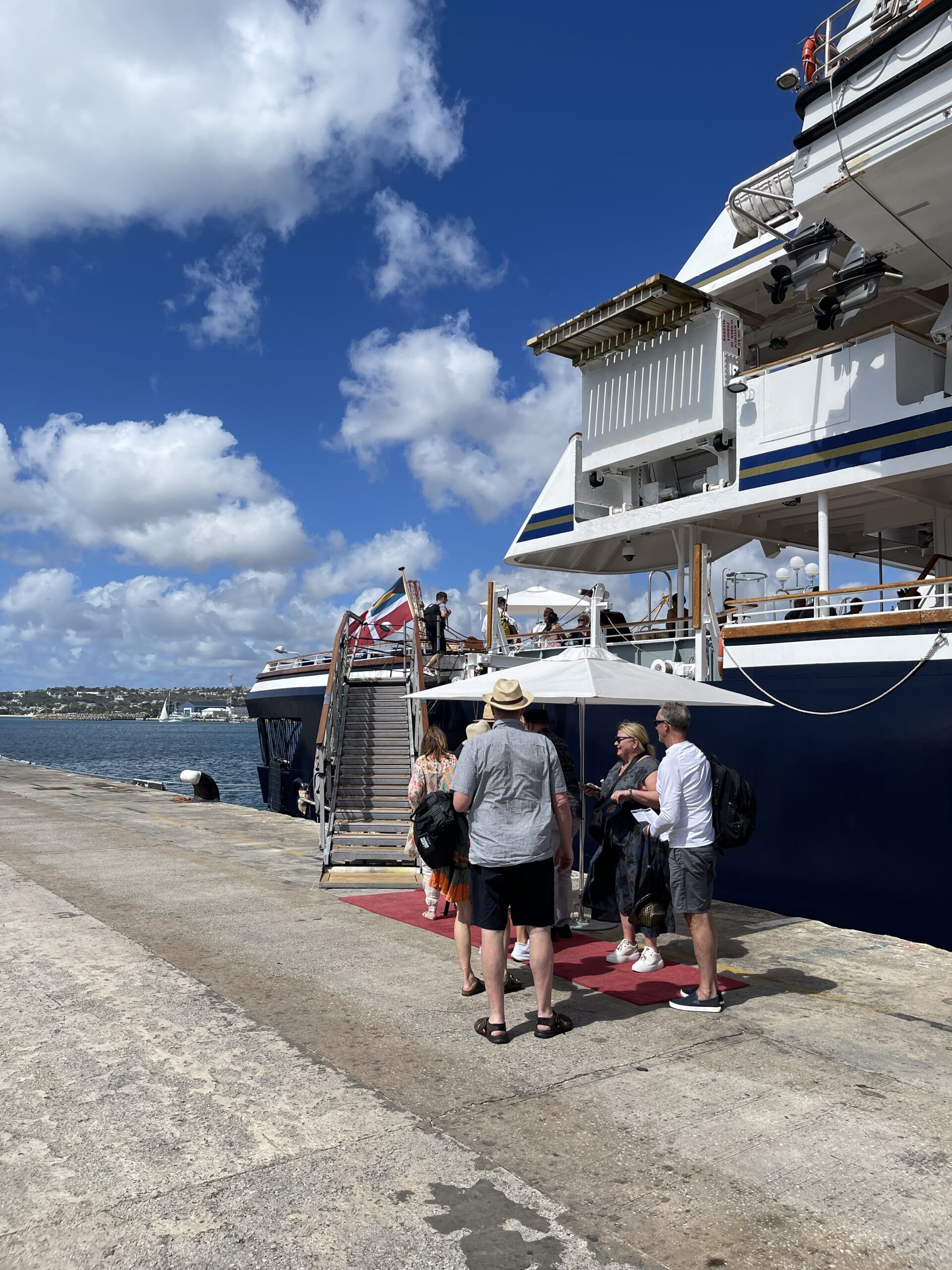 Mennesker går om bord yacht som ligger ved kaien. Foto