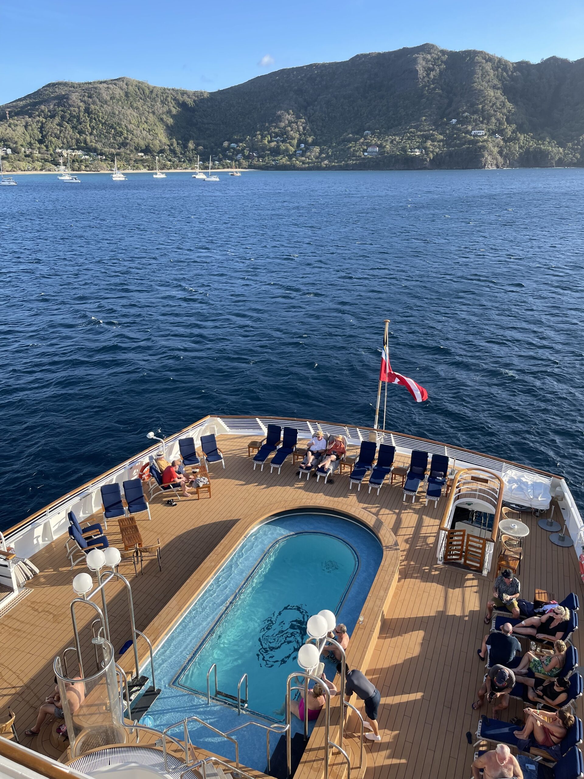 Bassengområde bakerst på yacht med solstoler rundt. Foto