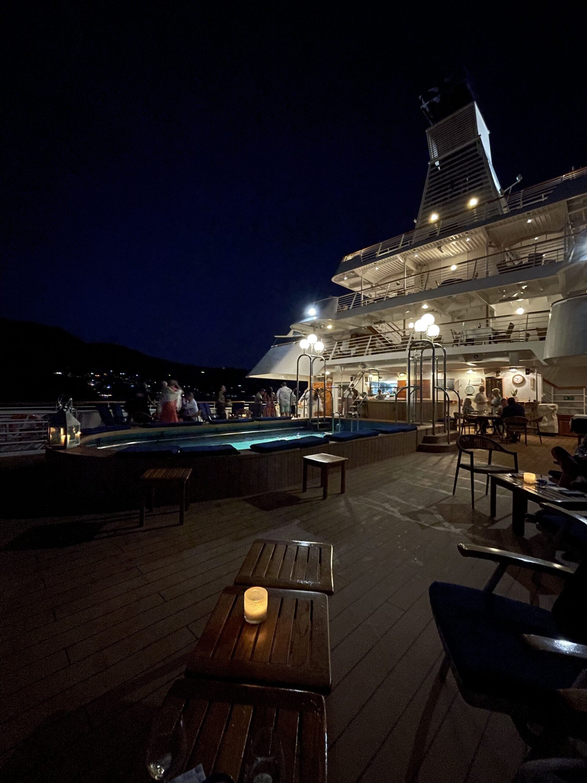 Tente lys og hyggelig stemning i mørket på dekk, om bord en yacht. Foto