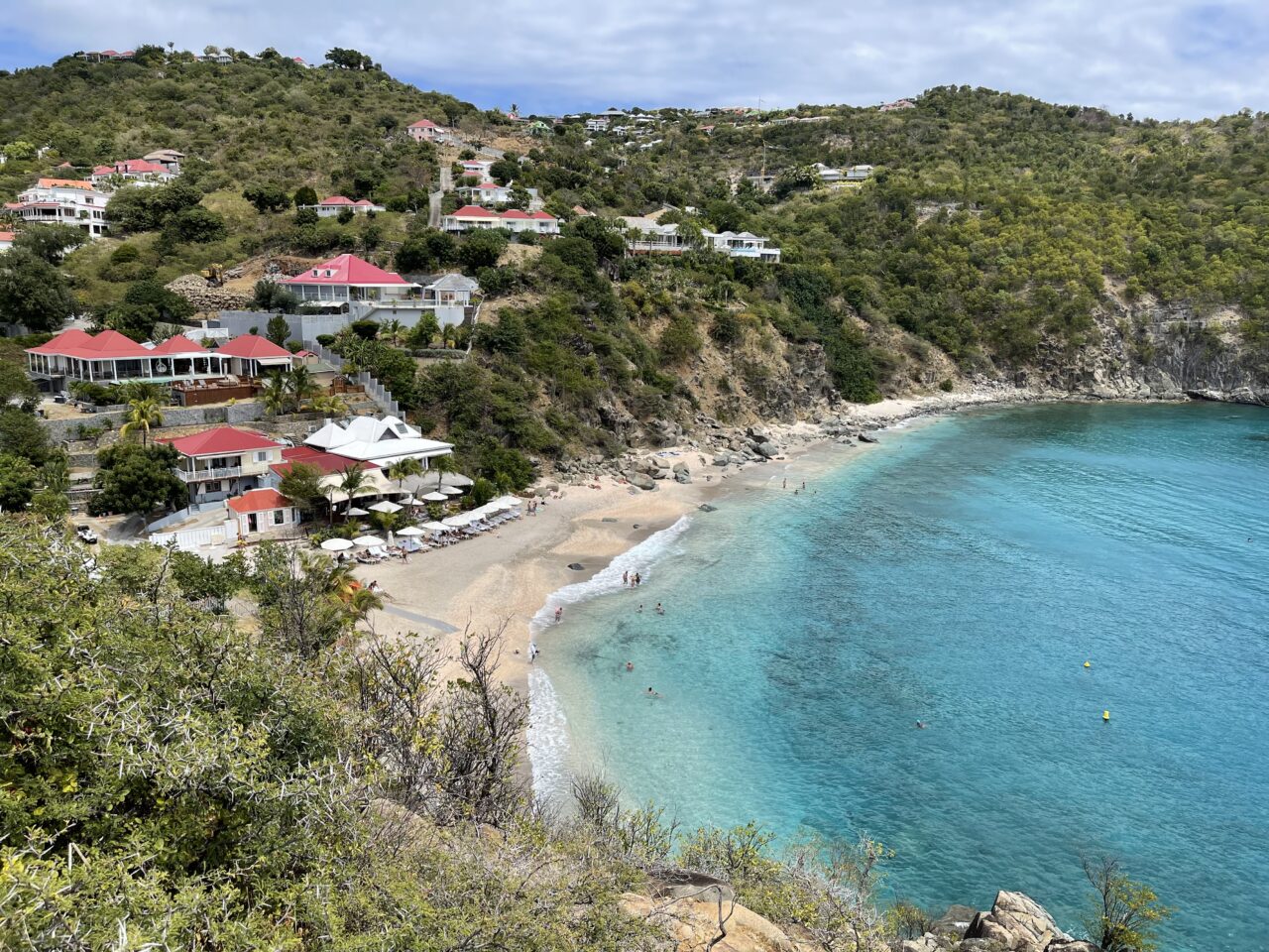 Utsiktsbilde over hus som ligger vakkert til ved en sandstrand. Foto