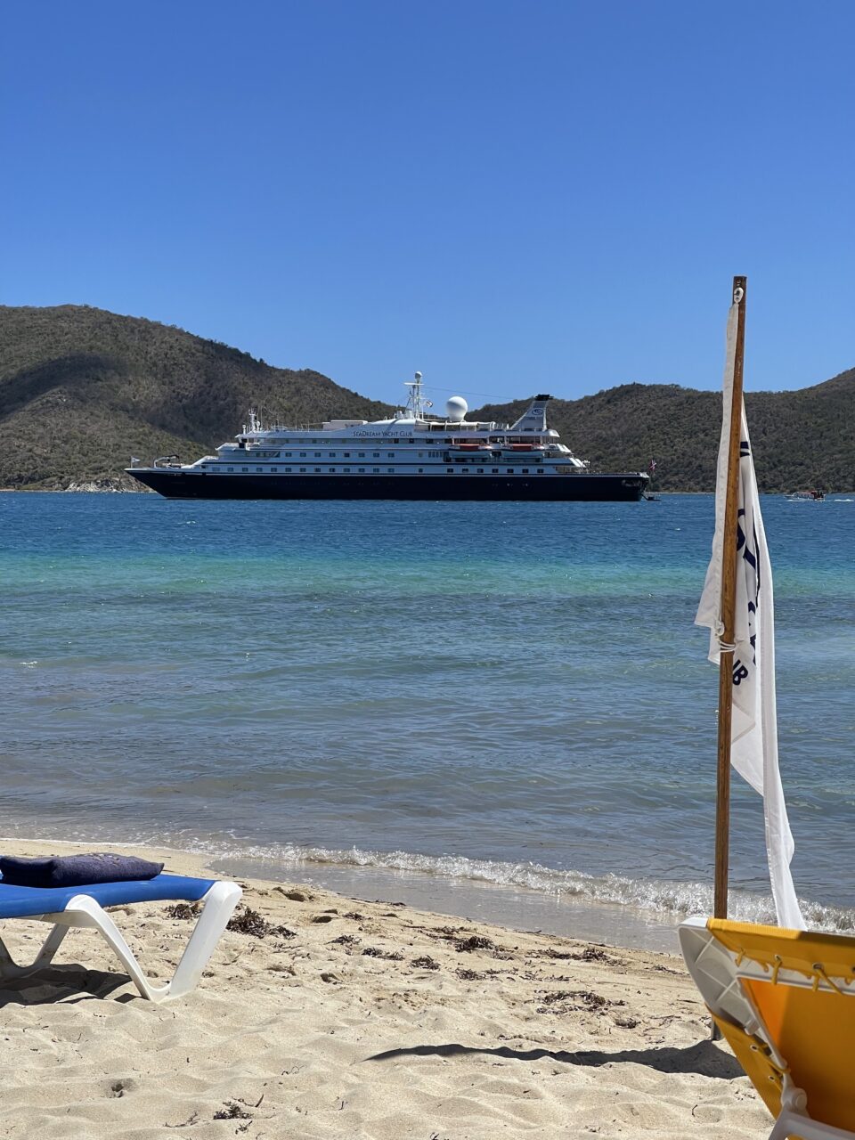 En stor yacht i havet tatt fra stranden. Foto