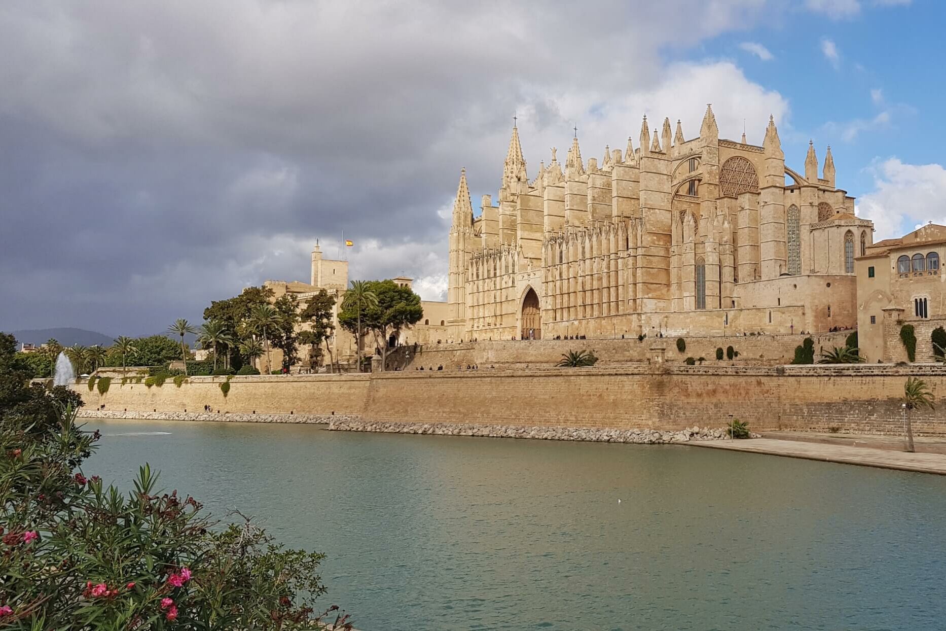 Utsikt over stor steinkatedral beliggende langs en kanal. Foto