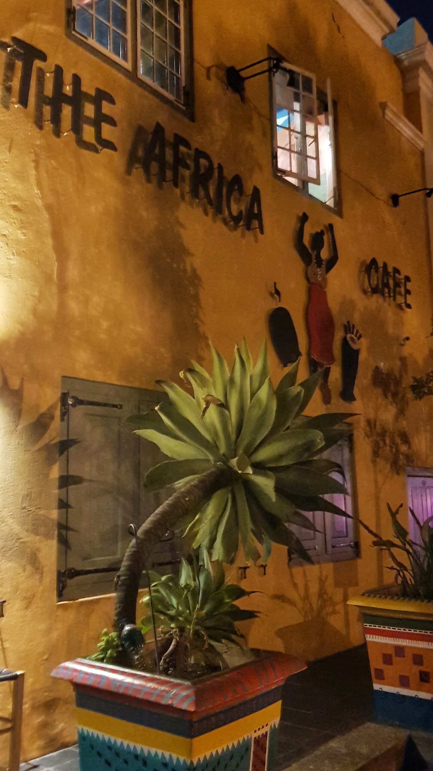 Dekorert gul vegg med skilt som sier "The Africa Cafe". Foto