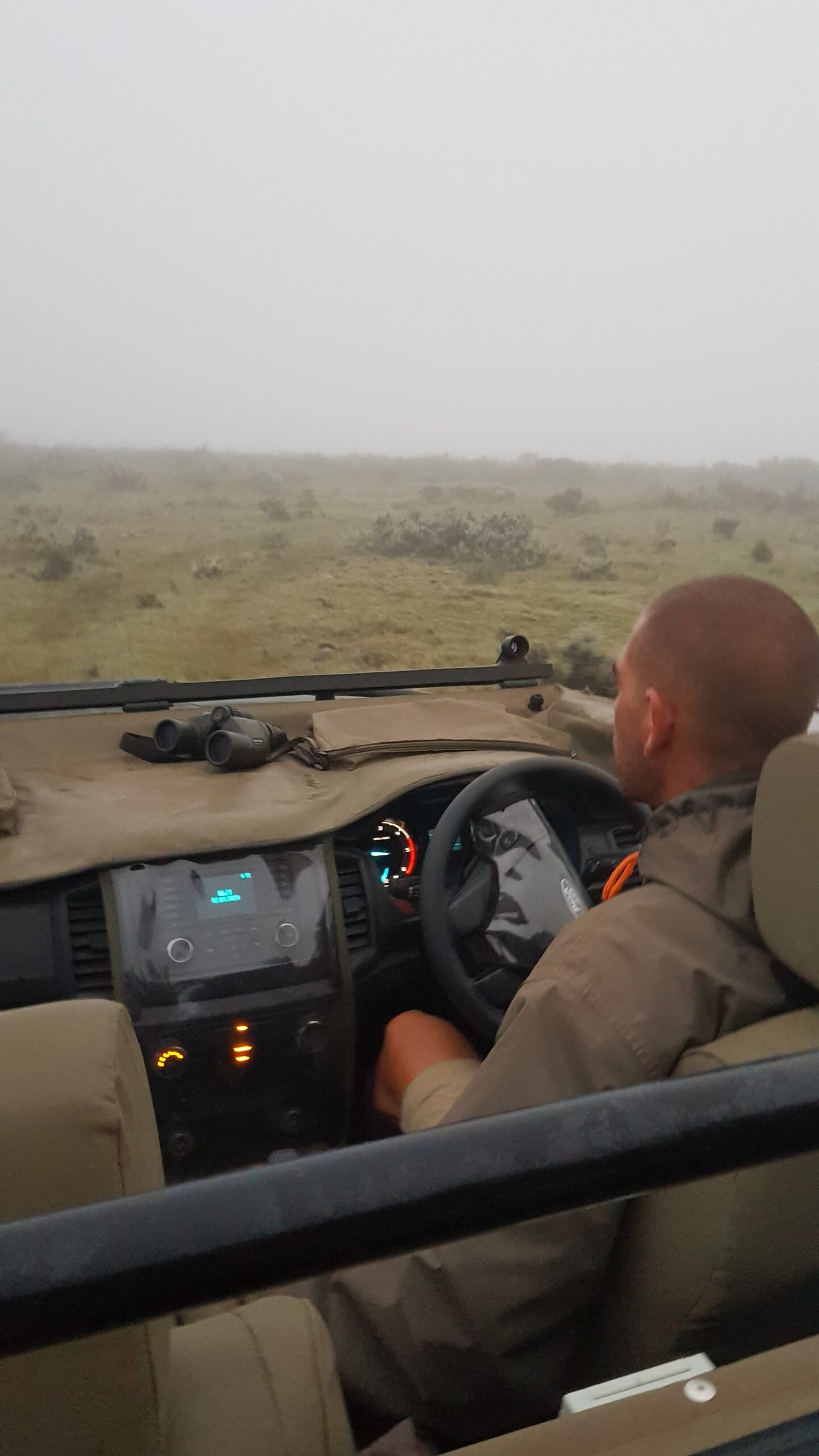 Mann kjører en Jeep inn i tåken. Foto