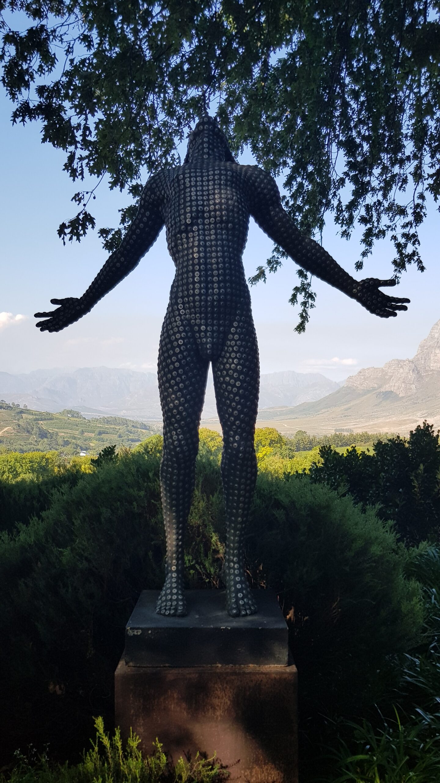 Statue av en mann som lener seg bakover og ser opp i himmelen. Foto