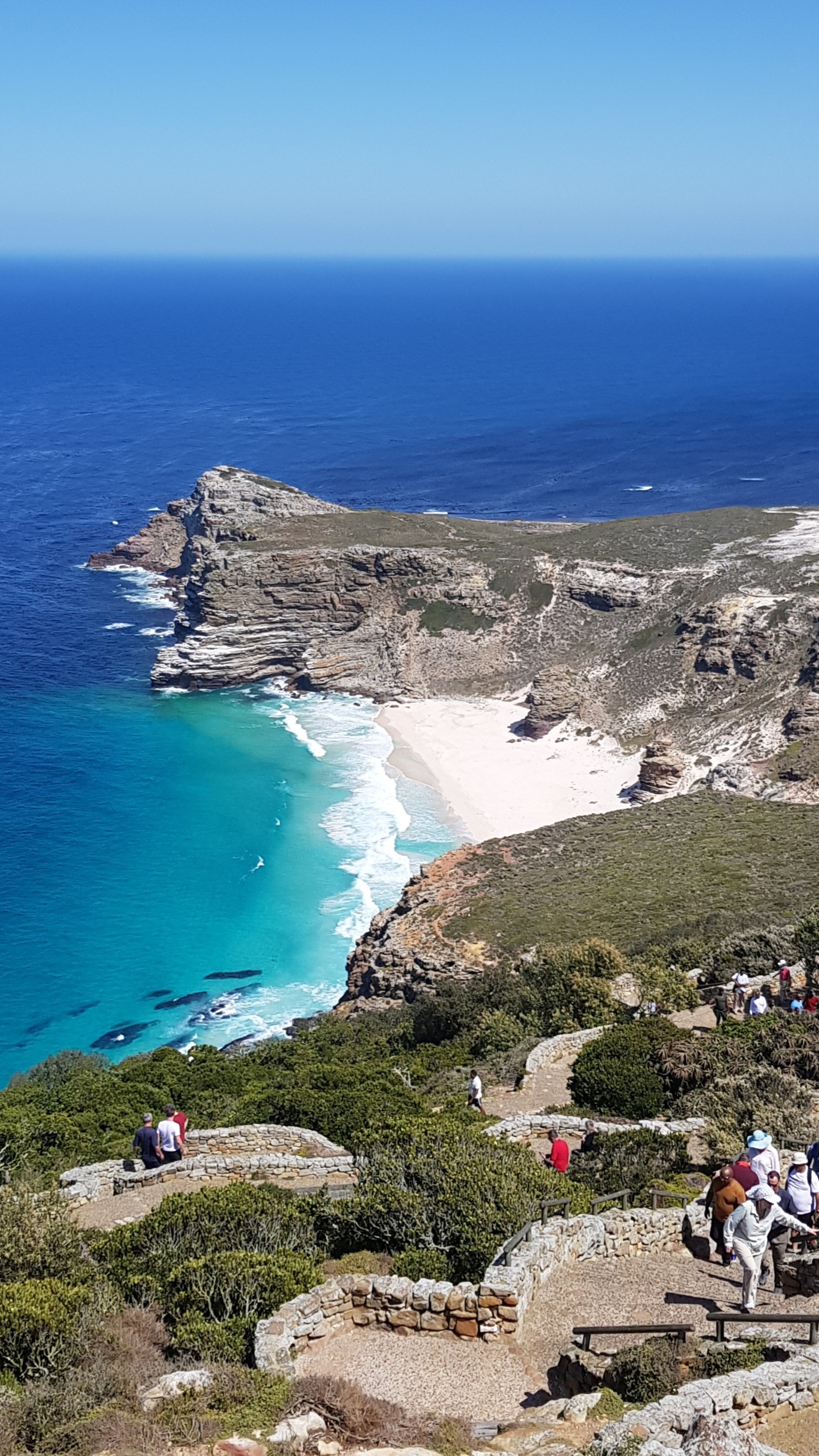 Utsikt ned mot en kritthvit sandstrand inne i en lagune. Foto