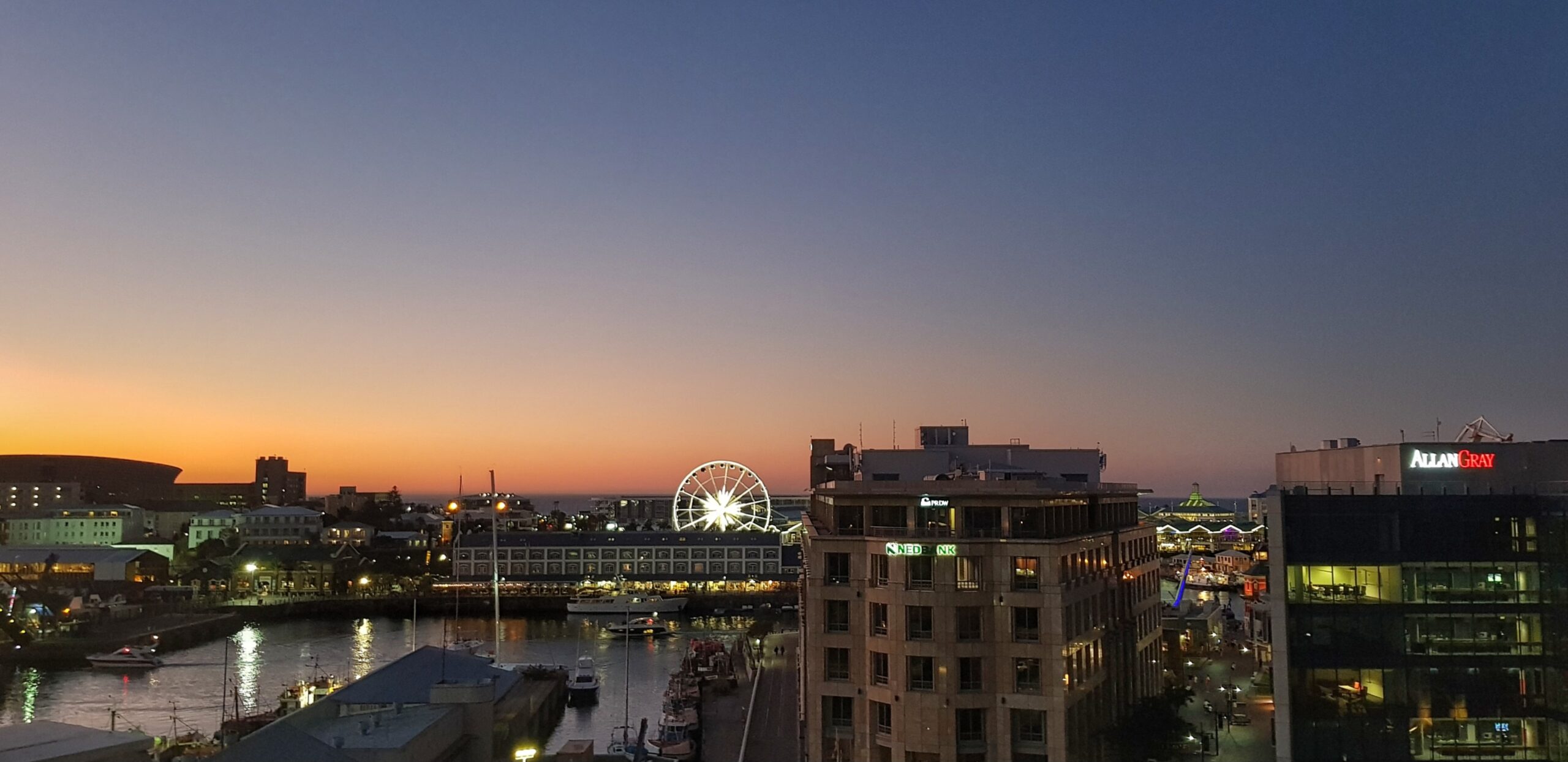 Oransje solnedgang i horisonten sett fra en takterrasse. Foto