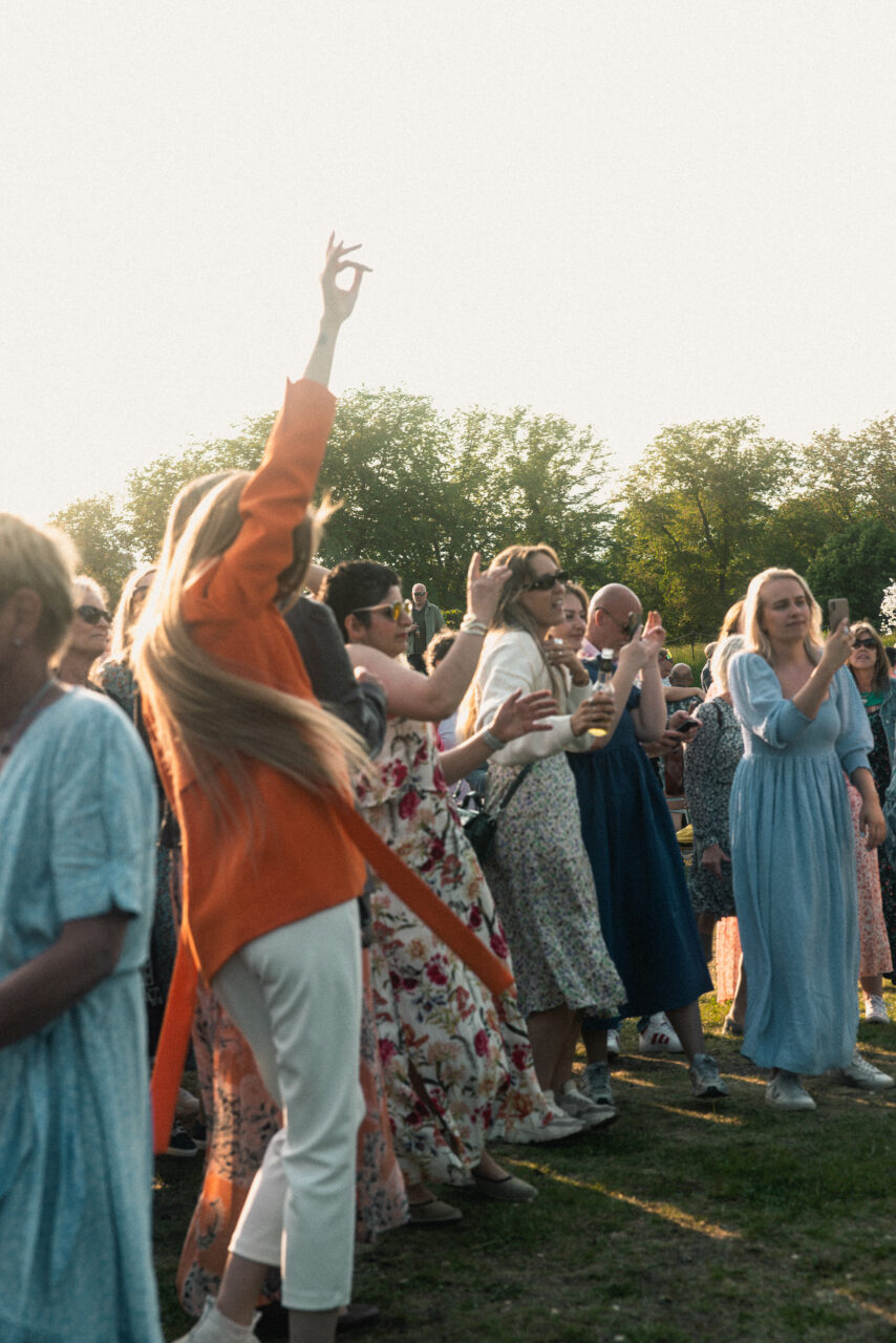 Jenter i sommerkjoler danser utendørs i fint sommervær. Foto