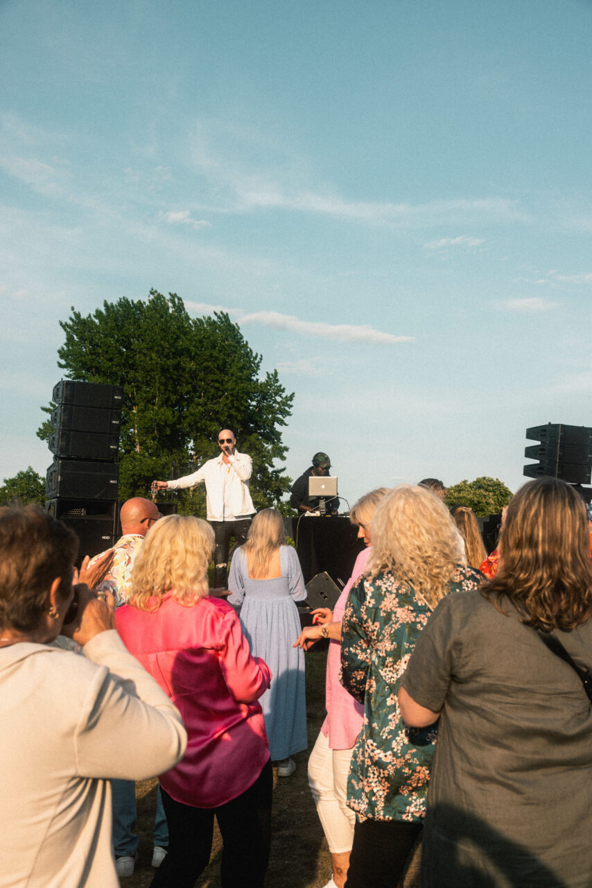 Artist står på scene og underholder for et publikum som danser. Foto