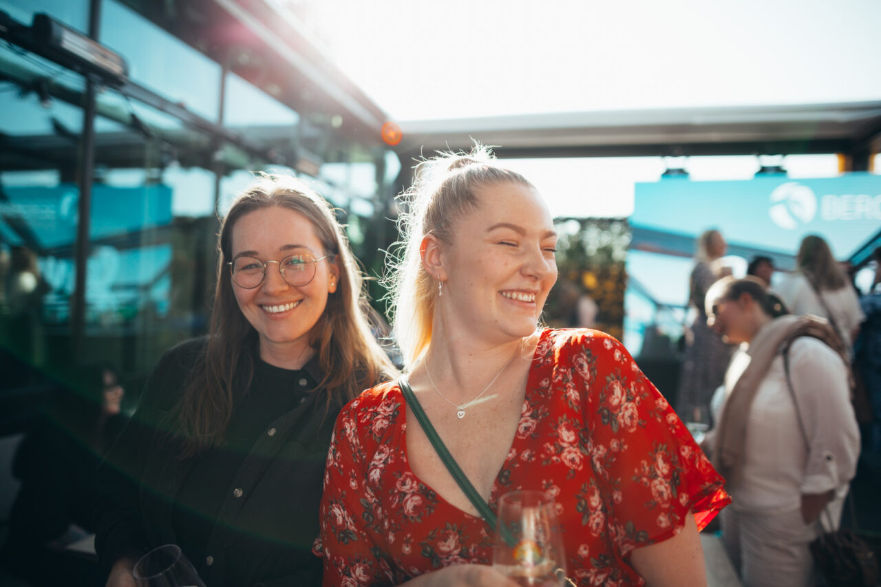 To smilende jenter som hygger seg på sommerfest. Foto