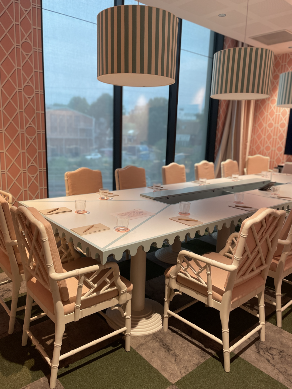 Et rosa møterom med langbord og stoler. Foto