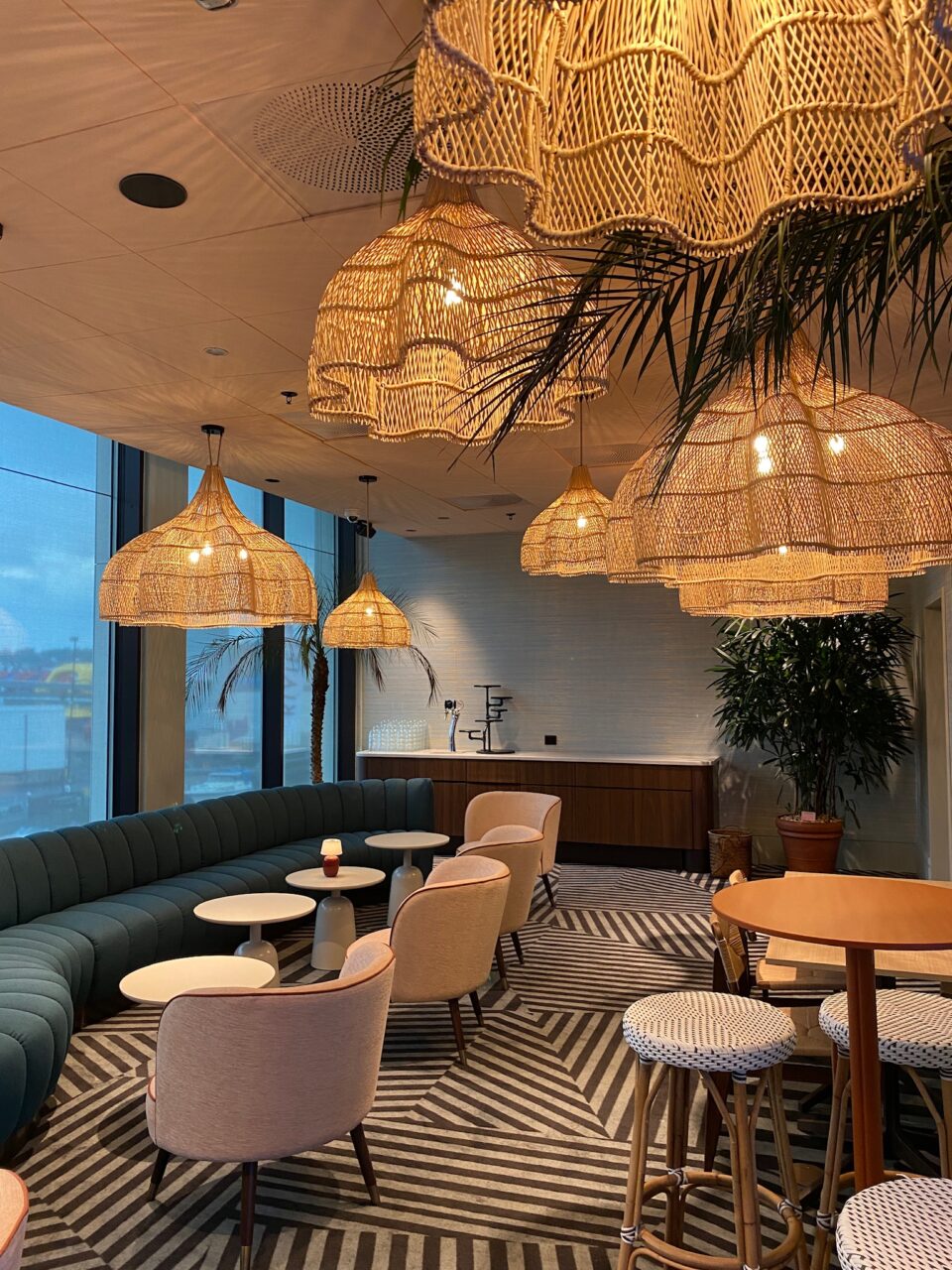 Oppholdsrom med lamper i strå, sofa og stoler. Foto