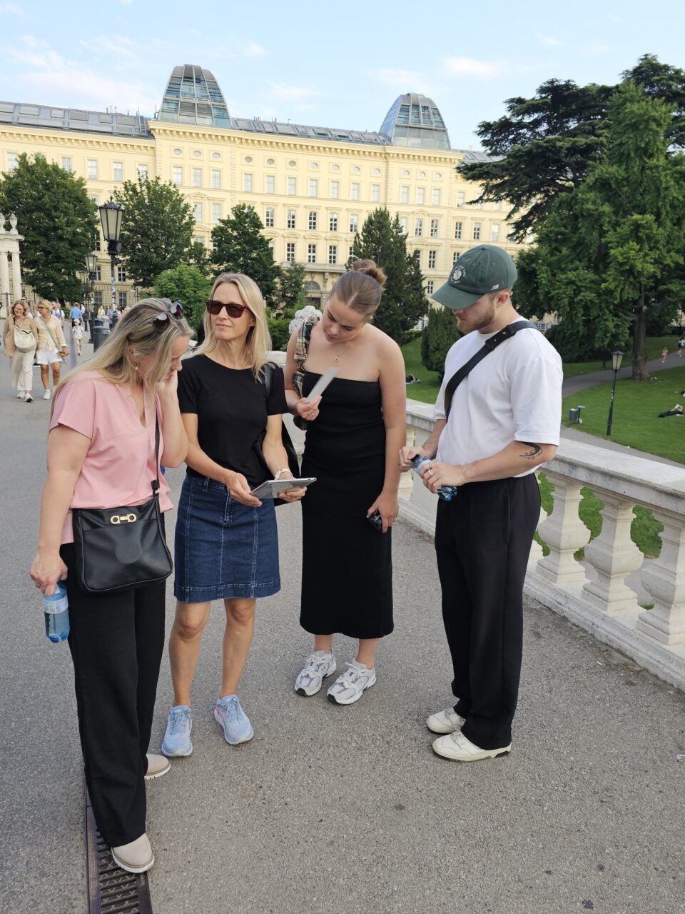 Liten gruppe mennesker står i byen med en iPad. Foto
