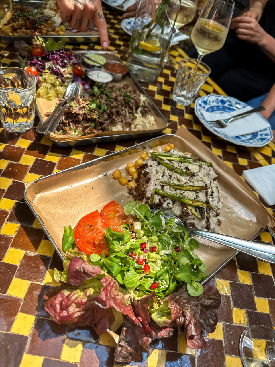 Kebab og salat tilberedt på store fat på et bord. Foto