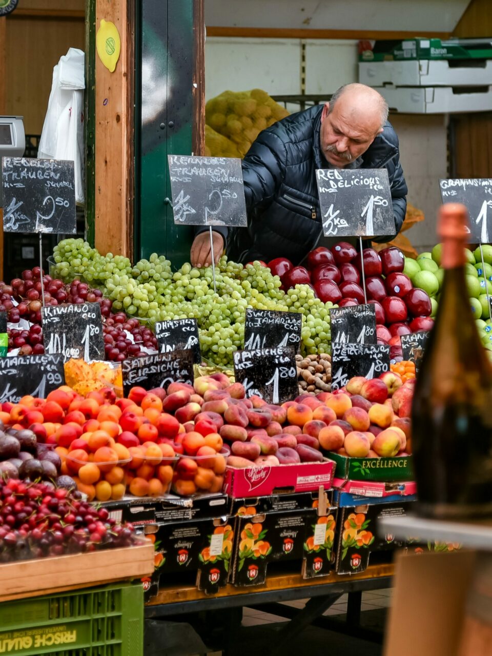 Mann står bak stor fruktbod. Foto