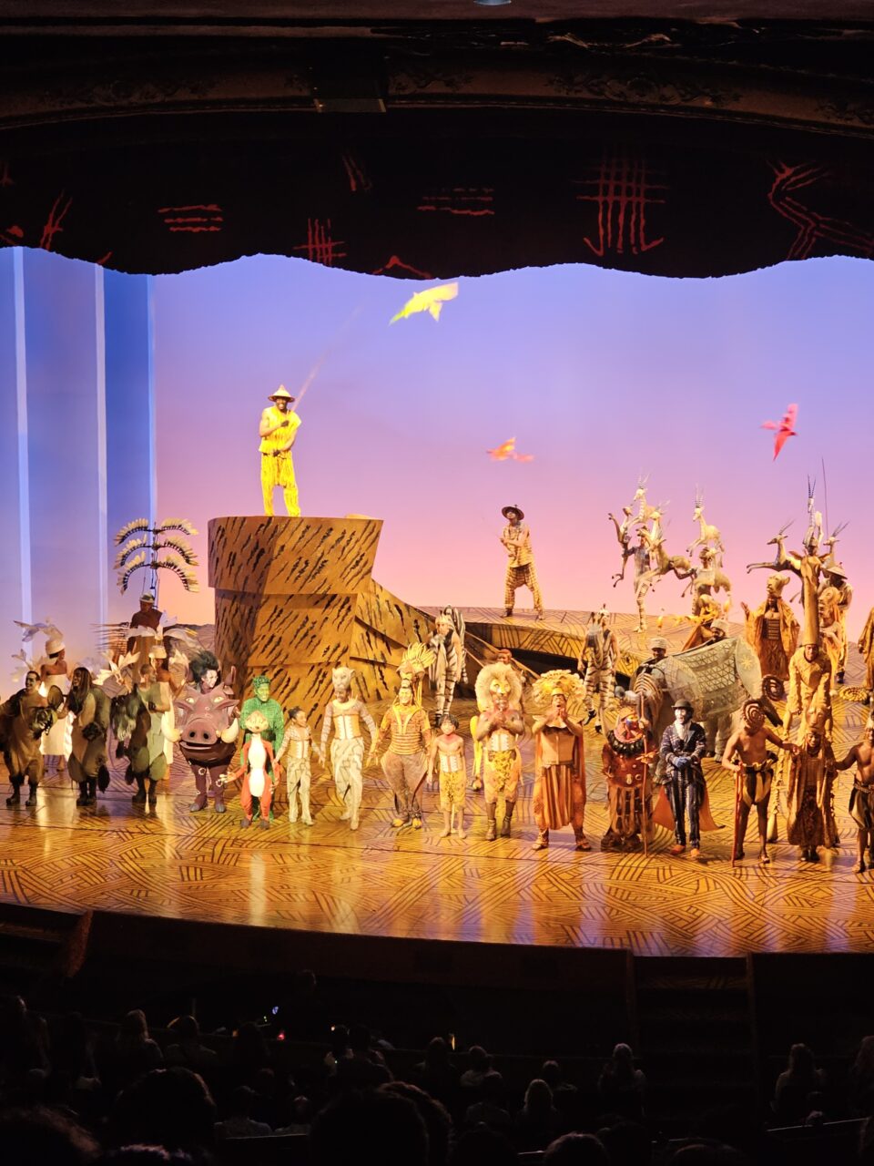 Alle skuespillerne i Lion King står på scenen og tar i mot applaus. Foto