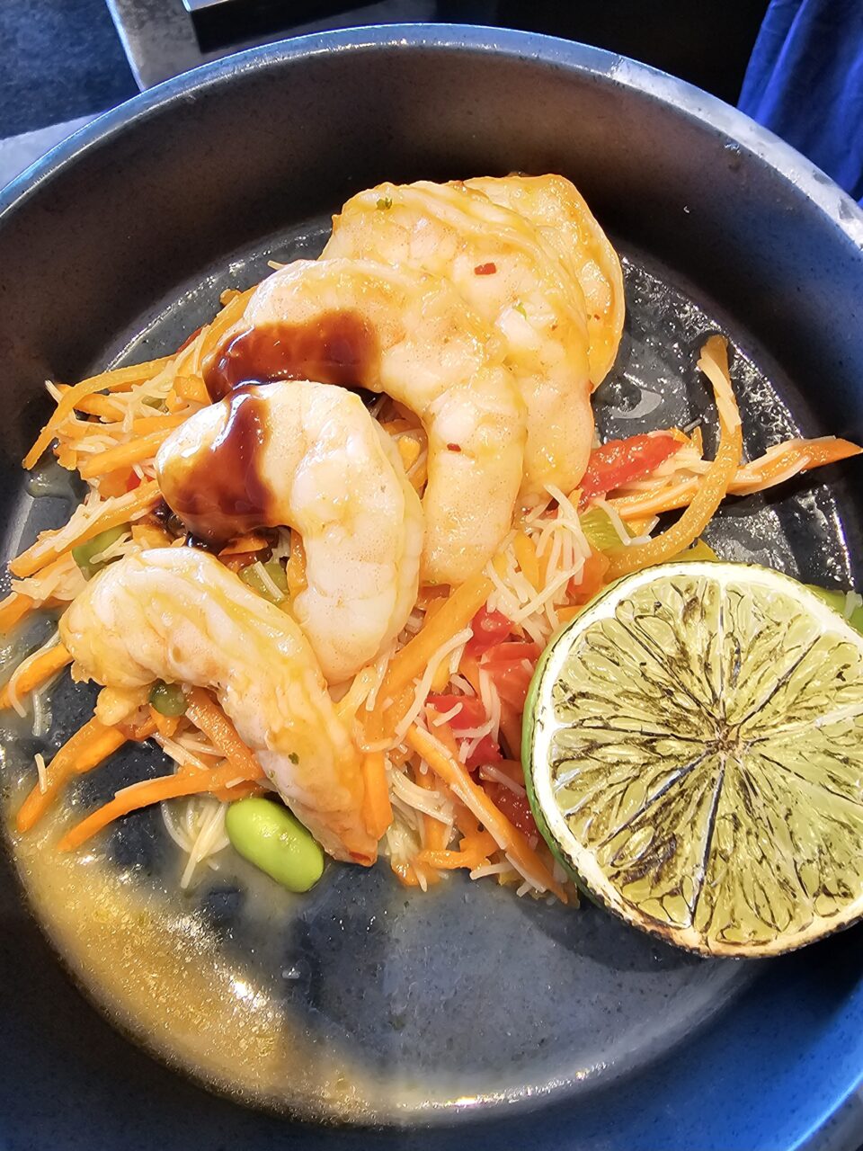 Tallerken med scampi, grønnsaker og lime. Foto