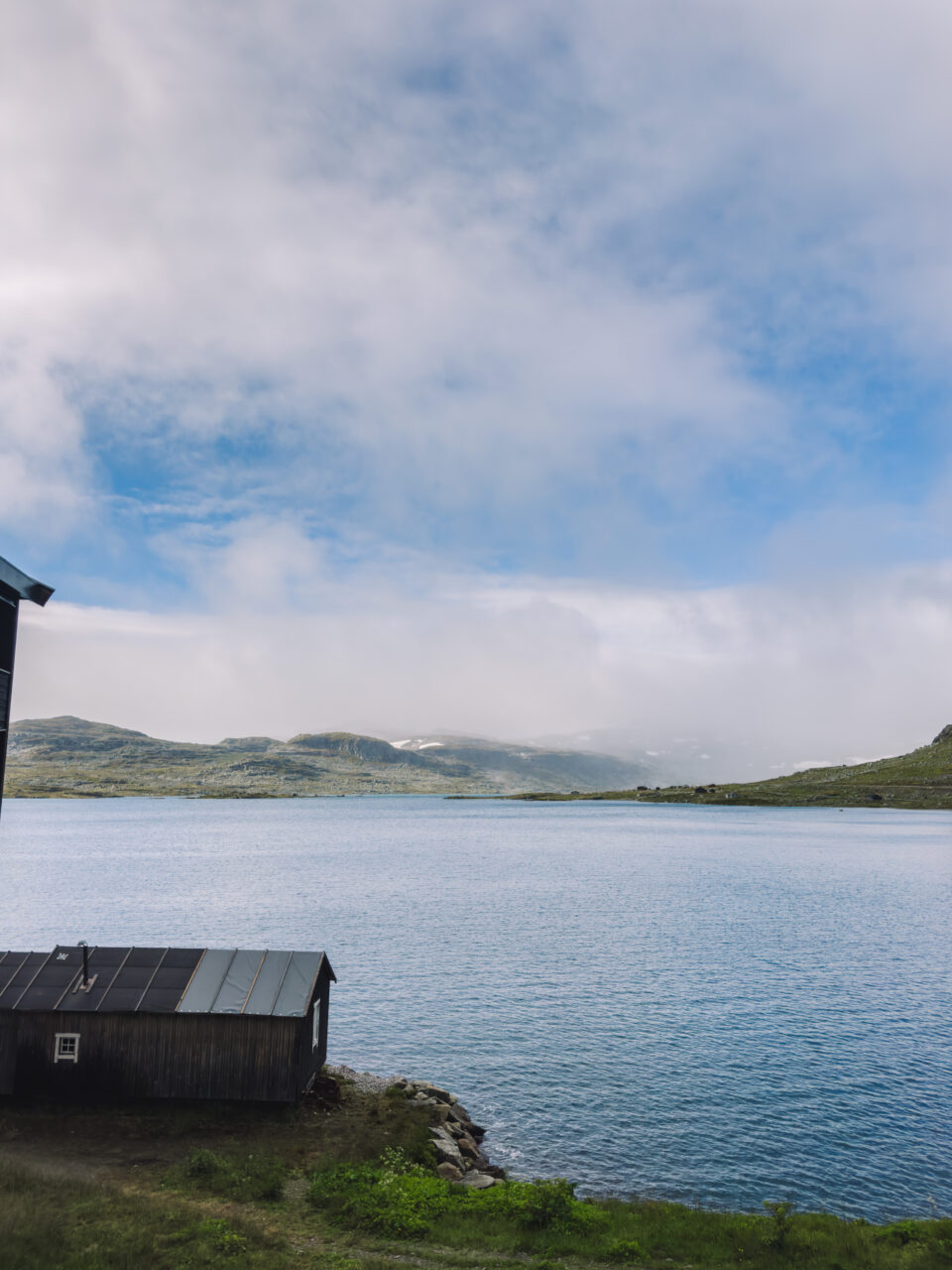 Utsiktsbilde over et vann med fjell i bakgrunnen. Foto