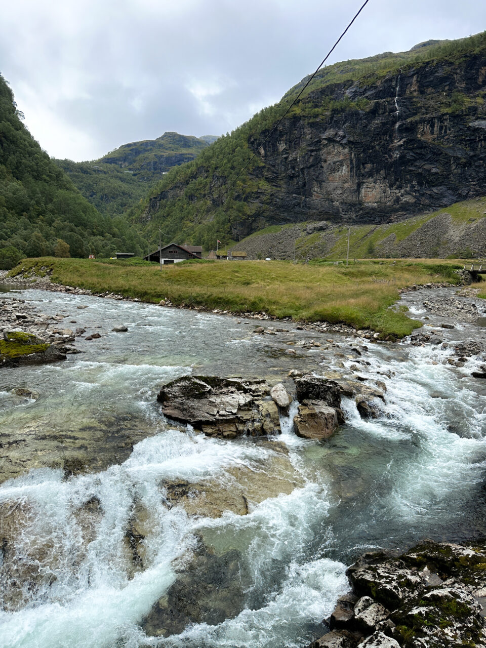 En bekk med klart vann som renner nedover en dal. Foto